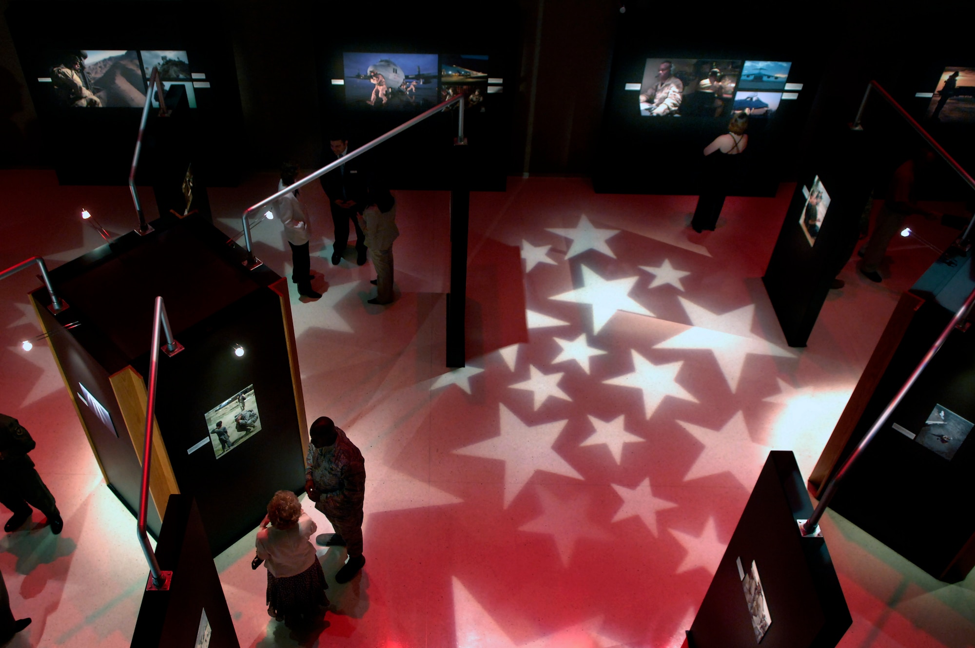 Patrons study photographs on display at the "On the Other Side of the Lens" exhibit May 1 at the National Museum of the U.S. Air Force on Wright-Patterson Air Force Base, Ohio. The exhibit features photographs taken of Airmen supporting the war on terrorism and runs through December. The exhibit recognizes Air Force photographers and their work. (U.S. Air Force photo/Tech.Sgt. Cecilio Ricardo) 