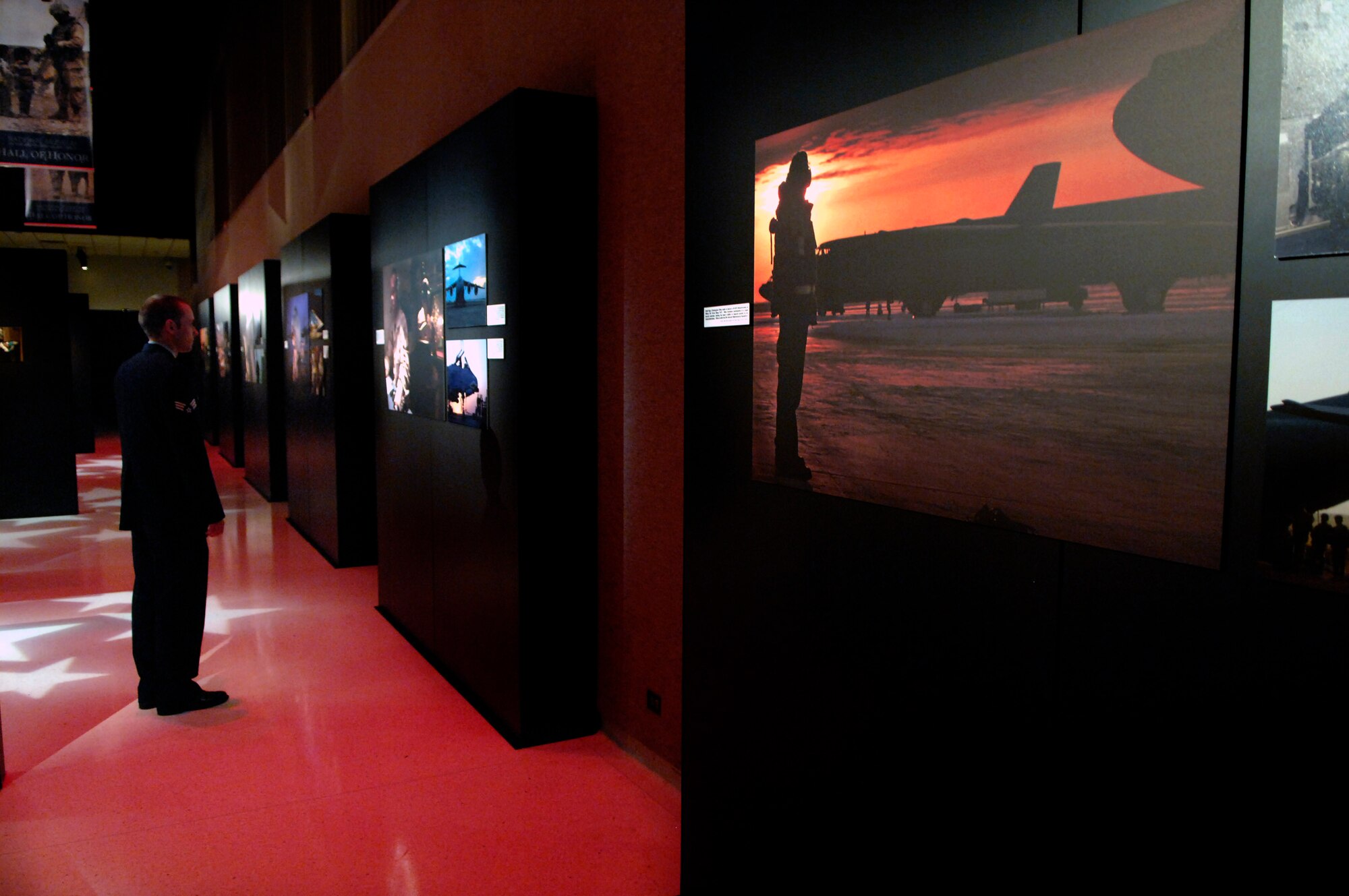 Senior Airman Chad Kellum takes a moment to check out Air Force photographs displayed in the "On the Other Side of the Lens" exhibit at the National Museum of the U.S. Air Force on Wright-Patterson Air Force Base, Ohio. Airman Kellum is one of the more than 30 Air Force photographers featured in the exhibit. The exhbit will run through December. (U.S. Air Force photo/Tech.Sgt. Cecilio Ricardo)
