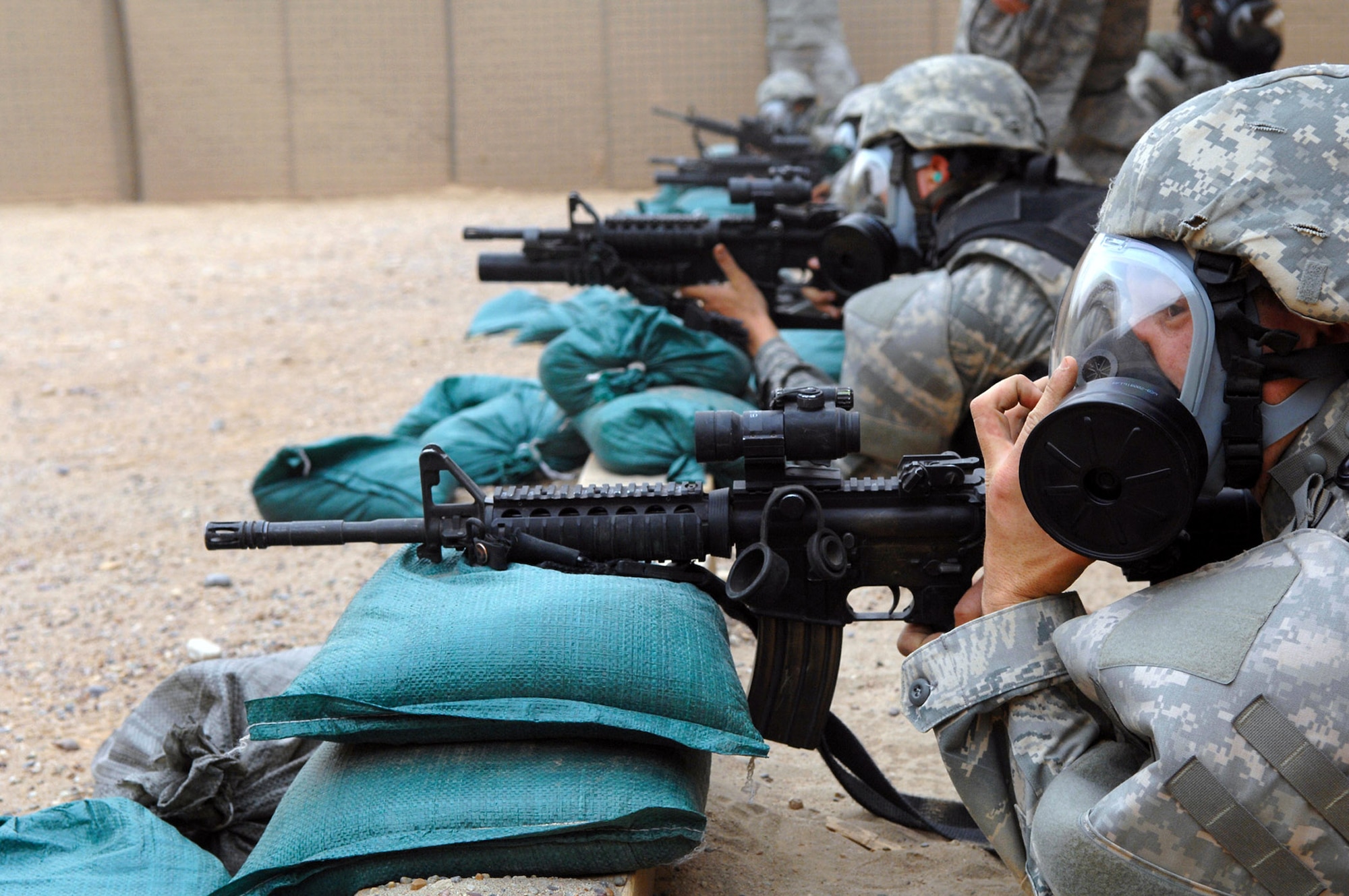 Airmen from the 332nd Expeditionary Security Forces Squadron fire M-4s with their gas masks on April 30 at Balad Air Base, Iraq. Security forces ensure the safety of Airmen on base so they can complete their missions and launch aircraft. This is the primary task of security forces personnel and is executed and practiced on a daily basis. (U.S. Air Force photo/Senior Airman Julianne Showalter) 
