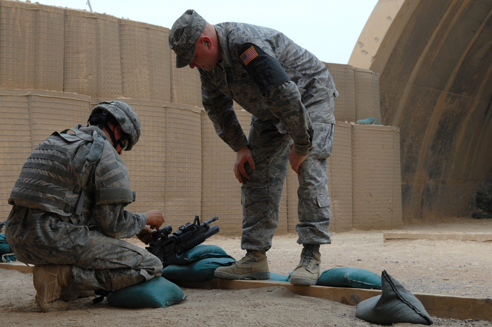 BALAD AIR BASE, Iraq -- Tech. Sgt. Steven Boling, 332nd Expeditionary Security Forces Squadron security forces, watches and assists Airman 1st Class Darryl Worthey, 332nd Expeditionary Security Forces Squadron security forces, as he sights in his scope here, April 30. Every person has a slightly different defensive fighting position so each weapon must be adjusted to the shooter. Sergeant Boling is deployed from Buckley Air Force Base, Colo., and Airman Worthey is deployed from Mountain Home Air Force Base, Idaho. (U.S. Air Force photo/ Senior Airman Julianne Showalter)