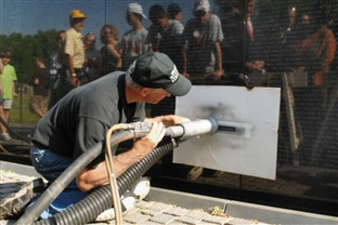 James Lee, who has engraved many names onto the Vietnam Veterans Memorial Wall, uses a sandblaster to stencil U.S. Marine Lance Cpl. Raymond C. Mason's name onto the Vietnam Veterans Memorial Wall during a ceremony, May 7, 2008, Washington, D.C. Mason died May 28, 2006, of complications from wounds he received Feb. 28, 1968, during the Tet Offensive. He was confined to a wheelchair since that time.