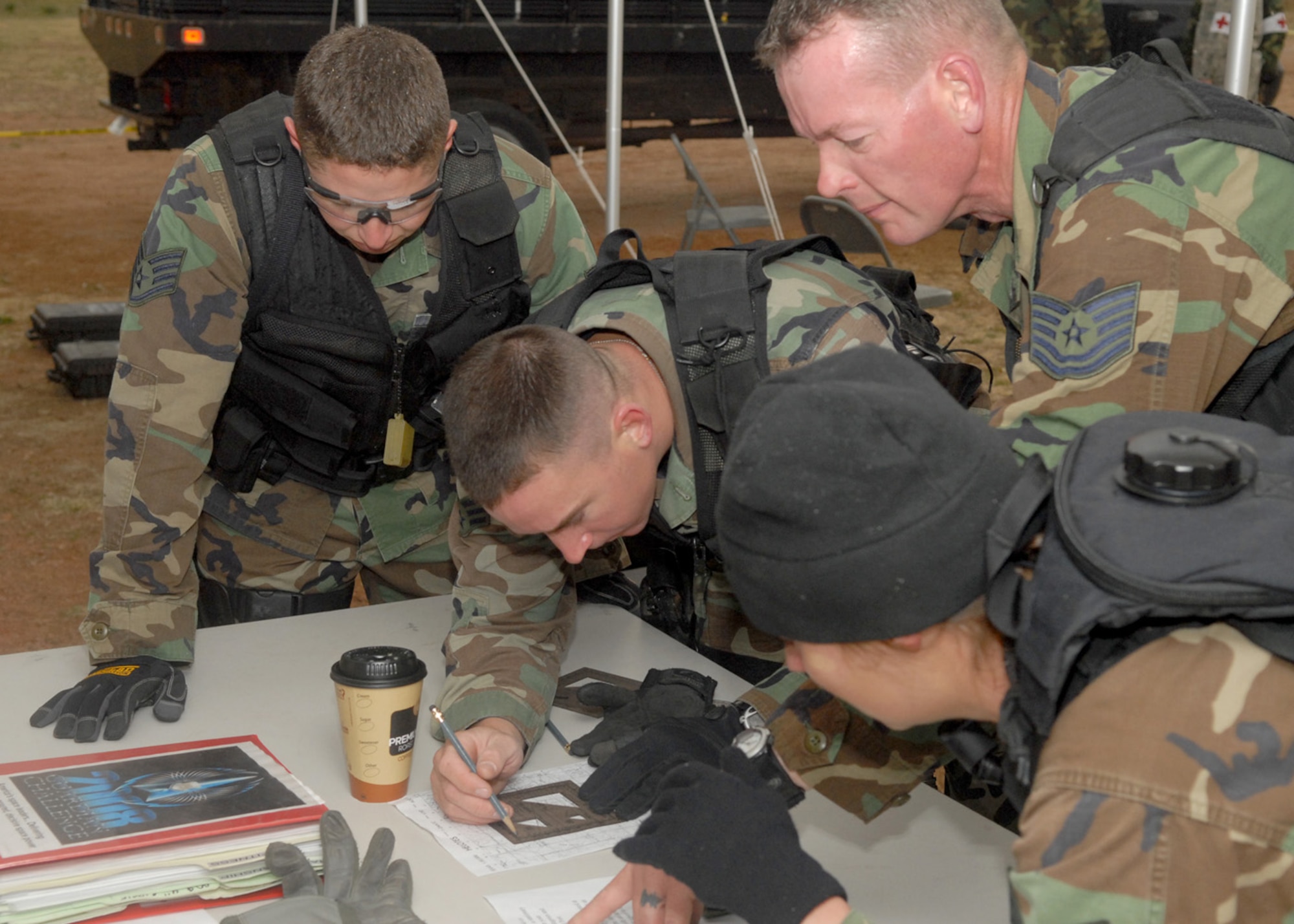 Staff Sgt. Aaron Trujillo, Senior Airman Matthew Masciorini, Tech. Sgt. Duane Blackmon, and Senior Airman Amanda Nye, Buckley's Security Forces Guardian Challenge team, demonstrate their land navigation expertise during the 2008 Guardian Challenge held at Peterson Air Force Base, Colo., May 1(U.S. Air Force photo by Airman 1st Class Randi Flaugh)