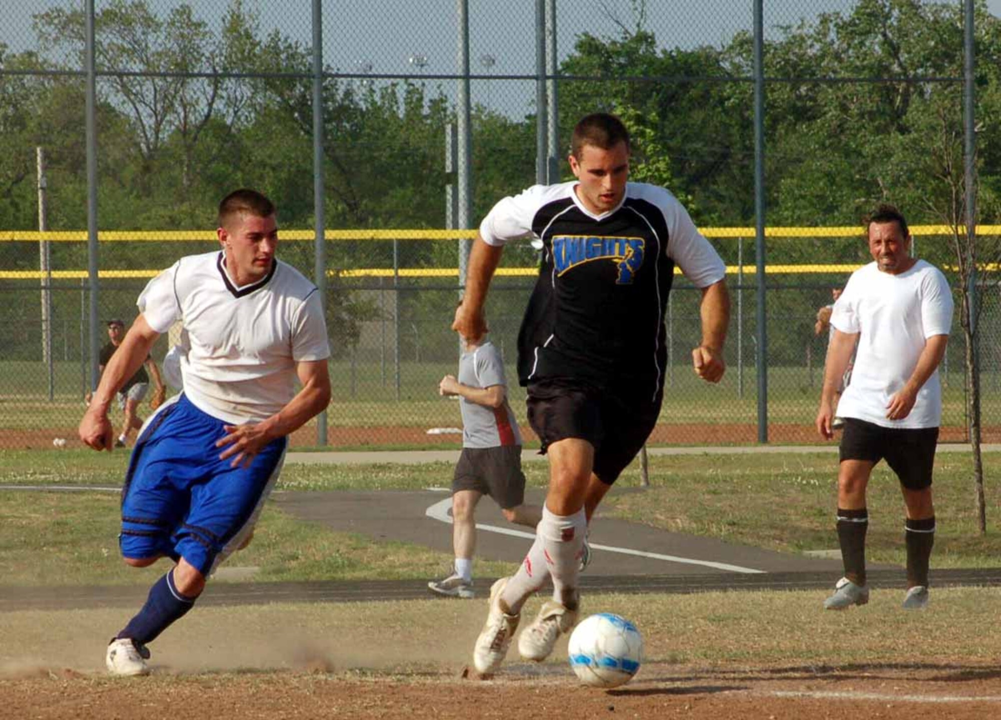 Justin Crawford, 963rd Airborne Air Control Squadron center back, dribbles the ball as 552nd MXS forward Mike Rosenthal tries to get the ball from him during a n April 30 match. The 963rd AACS won 3-0.  (Air Force photo by John E. Banks)