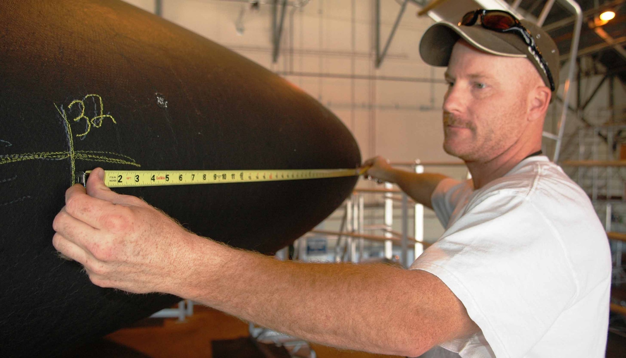 Scott Richardson, 76th Aircraft Maintenance Squadron, performs non-destructive inspection call tap testing on an E-3 Sentry Raydome to assess damage from the hail story that hit Tinker May 1.  (Air Force photo by Brion Ockenfels)