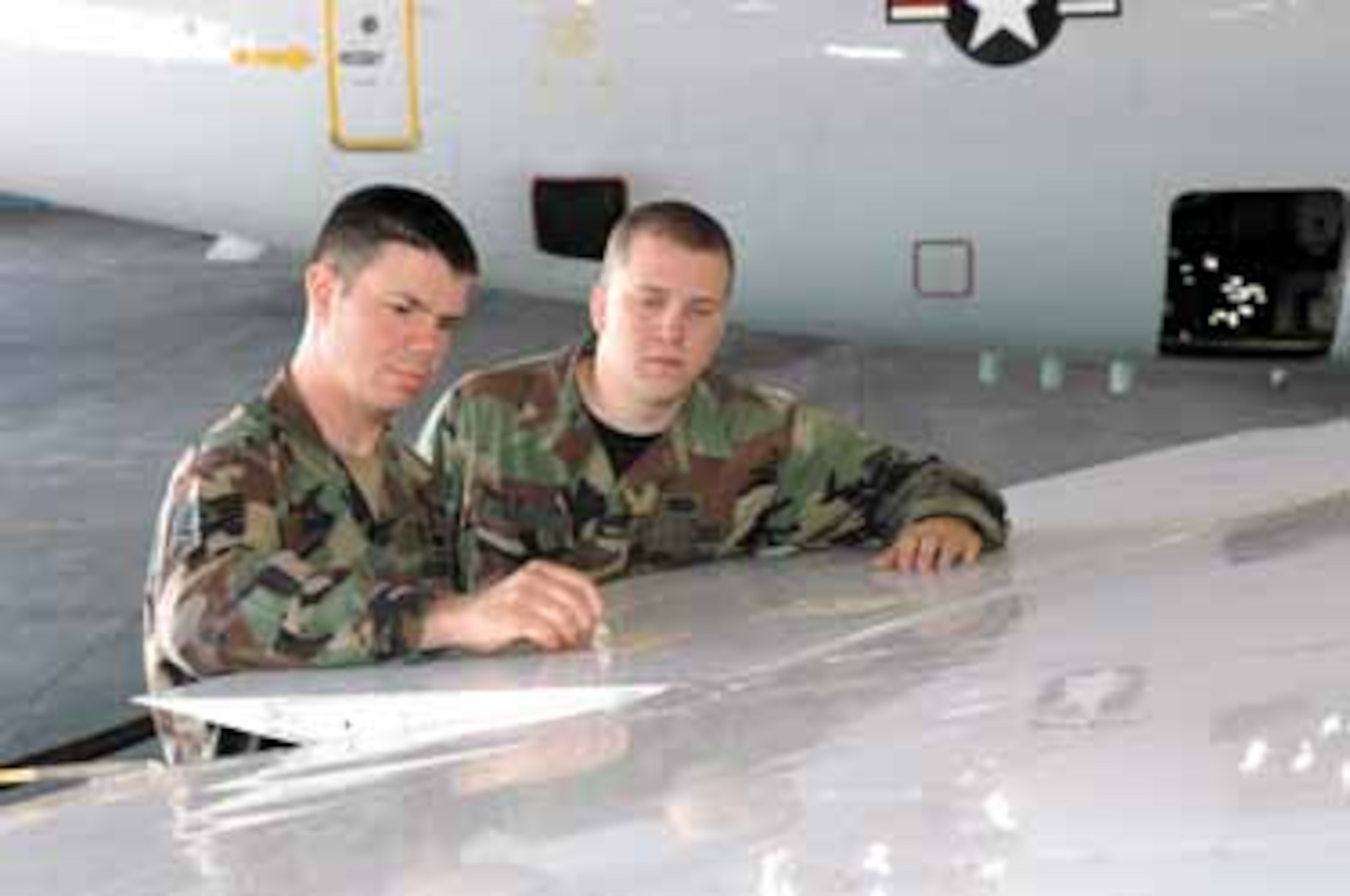 Airmen from the 552nd Maintenance Squadron perform coin tap test with quarters on outboard ailerons of an E-3 Sentry to assess damage from the hail storm that hit Tinker Air Force Base May 1.  Staff Sgt. Terry Shadduck, left, and Senior Airman Brian Volkmar, both airctaft structural maintenance technicians from the fabrication and sheet meal shop, perform inspections on the starboard (right side) ailerons.  (Air Force photo by Brion Ockenfels)