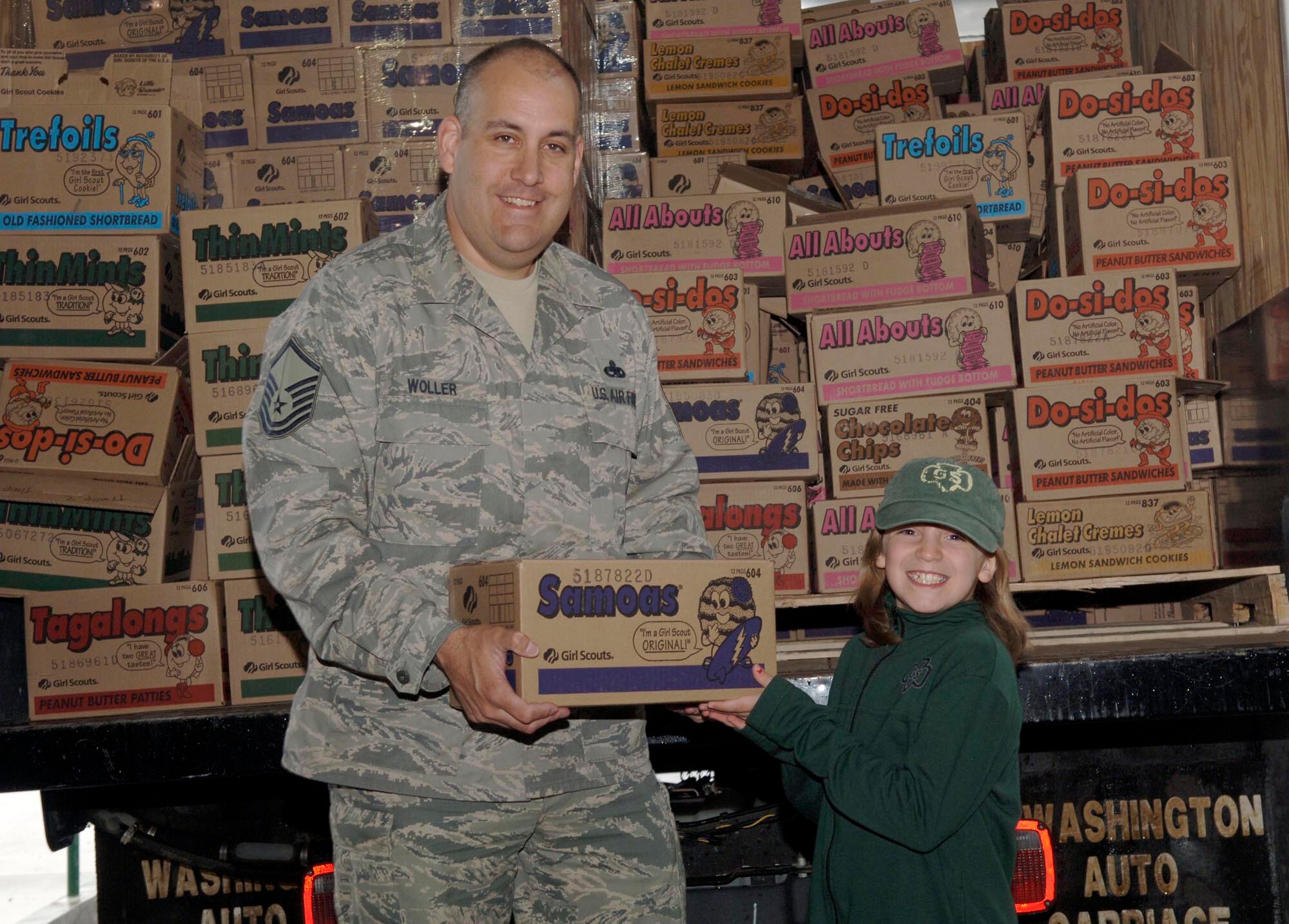 FAIRCHILD AIR FORCE BASE, Wash. – Master Sgt. Scott Woller, 92nd Mission Support Squadron, and Morgan Thompson, three-year Girl Scout, pose with the last case of cookies at the Crown warehouse in Spokane Valley, Wash., May 7. There were more than 600 cases given to the Airman & Family Readiness Center for military members and deploying troops. (U.S. Air Force photo / Airman 1st Class Darlene West)