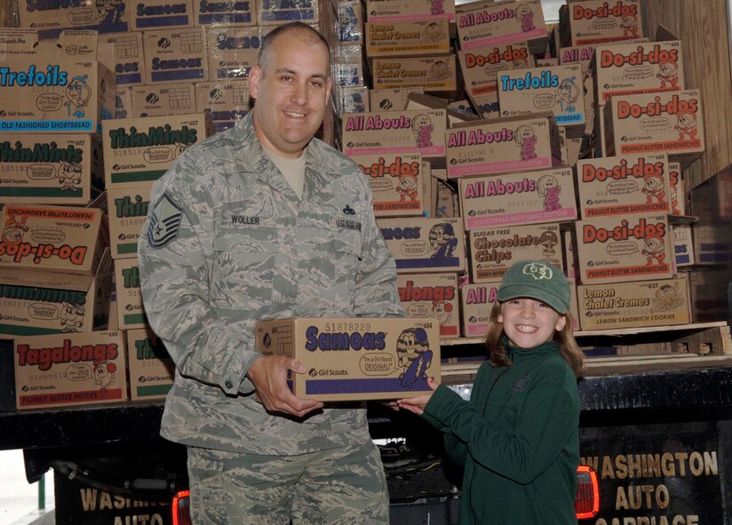 FAIRCHILD AIR FORCE BASE, Wash. – Master Sgt. Scott Woller, 92nd Mission Support Squadron, and Morgan Thompson, three-year Girl Scout, pose with the last case of cookies at the Crown warehouse in Spokane Valley, Wash., May 7. There were more than 600 cases given to the Airman & Family Readiness Center for military members and deploying troops. (U.S. Air Force photo / Airman 1st Class Darlene West)