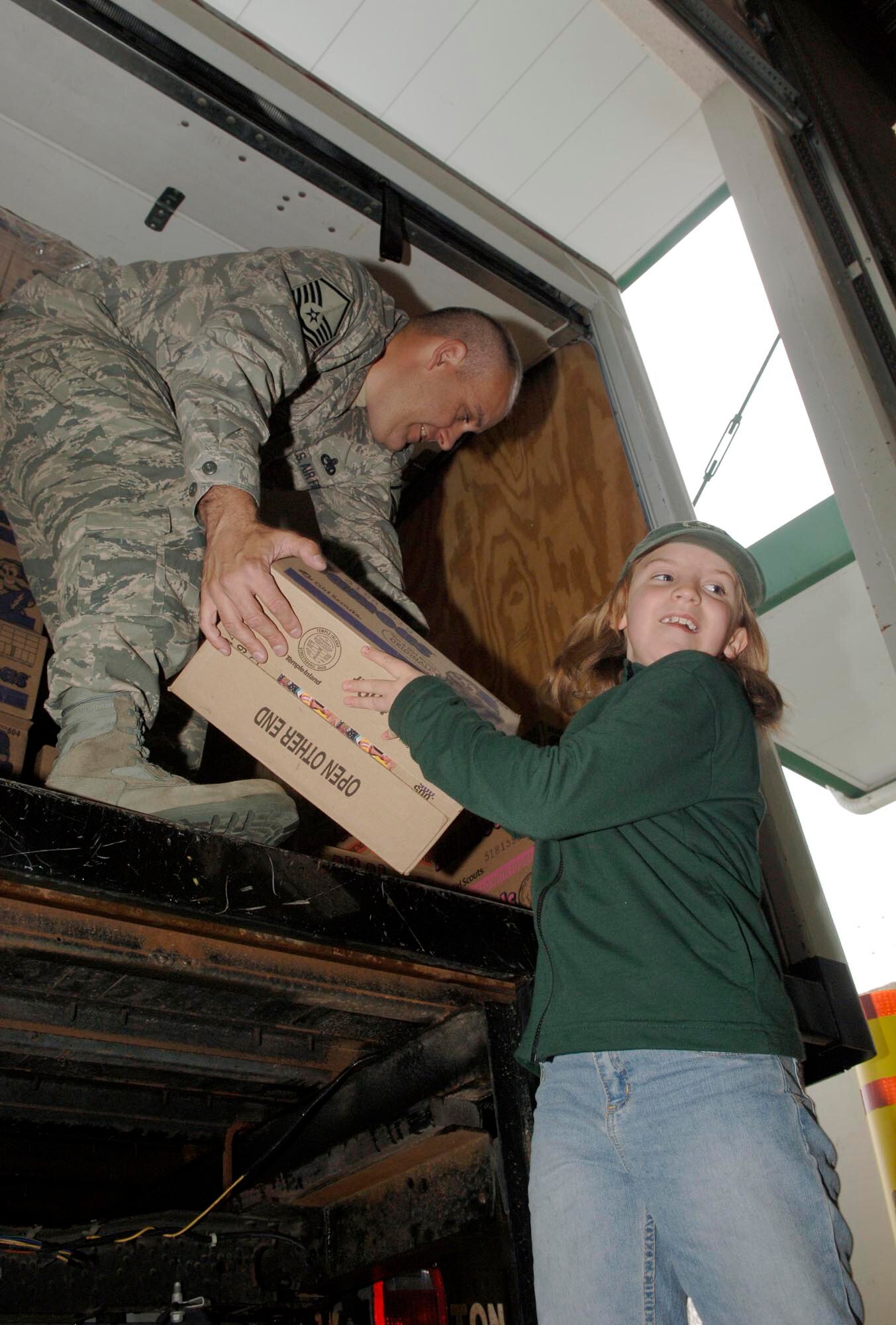 FAIRCHILD AIR FORCE BASE, Wash. – Master Sgt. Scott Woller, 92nd Mission Support Squadron Airman & Family Readiness Center, and Morgan Thompson, three year Girl Scout, loads cases of Girl Scout cookies into a truck at the Crown warehouse in Spokane Valley, Wash., May 7. The cookies were donated by 32 different counties across the states of Washington, Idaho, and Oregon for military members. (U.S. Air Force photo / Airman 1st Class Darlene West)