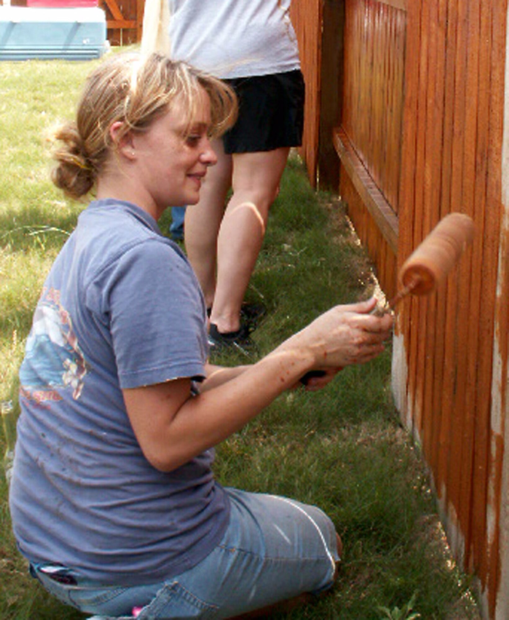 Staff Sgt. Sara Digennaro applies waterproofing to a fence as part of a volunteer effort supporting Operation Homefront April 30 in Cibolo, Texas. Volunteers from the Top 3 Association from Air Force Personnel Center from Randolph Air Force Base, Texas, helped craft a gate to provide better access between the front and back yards for Tech. Sgt. Israel Del Toro, an Airman recovering from wounds sustained during a roadside bombing in Afghanistan. Sergeant Digennaro is a personnelist at AFPC. (U.S. Air Force photo/Master Sgt. Kat Bailey)
