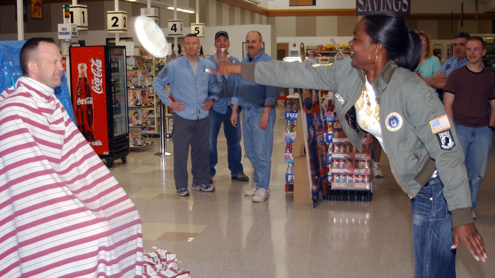 Senior Master Sgt. Dave Kelch, 741st Missile Security Forces Squadron first sergeant, winces in anticipation as Airman 1st Class Precious Celestine, 741st MSFS member, rockets a whipped-cream pie at his face during "Single Airman's Night" at the base commissary May 4. (U.S. Air Force photo/Airman 1st Class Dillon White)              