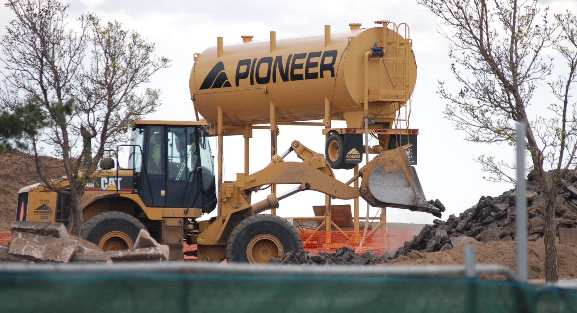 An Actus-Lend Lease contractor scraps together old concrete and asphalt from the remnants of Mitchell Street in the new base housing construction site at Peterson Air Force Base, Colo. Mitchell Street, east of Westover Street, closed May 5 due to new housing construction. The road closure is permanent. Members seeking access to this portion of base will be re-routed through Selfridge and Otis Streets. Stay with www.peterson.af.mil for the latest in base housing and construction news. (U.S. Air Force photo/Master Sgt. James Rush) 