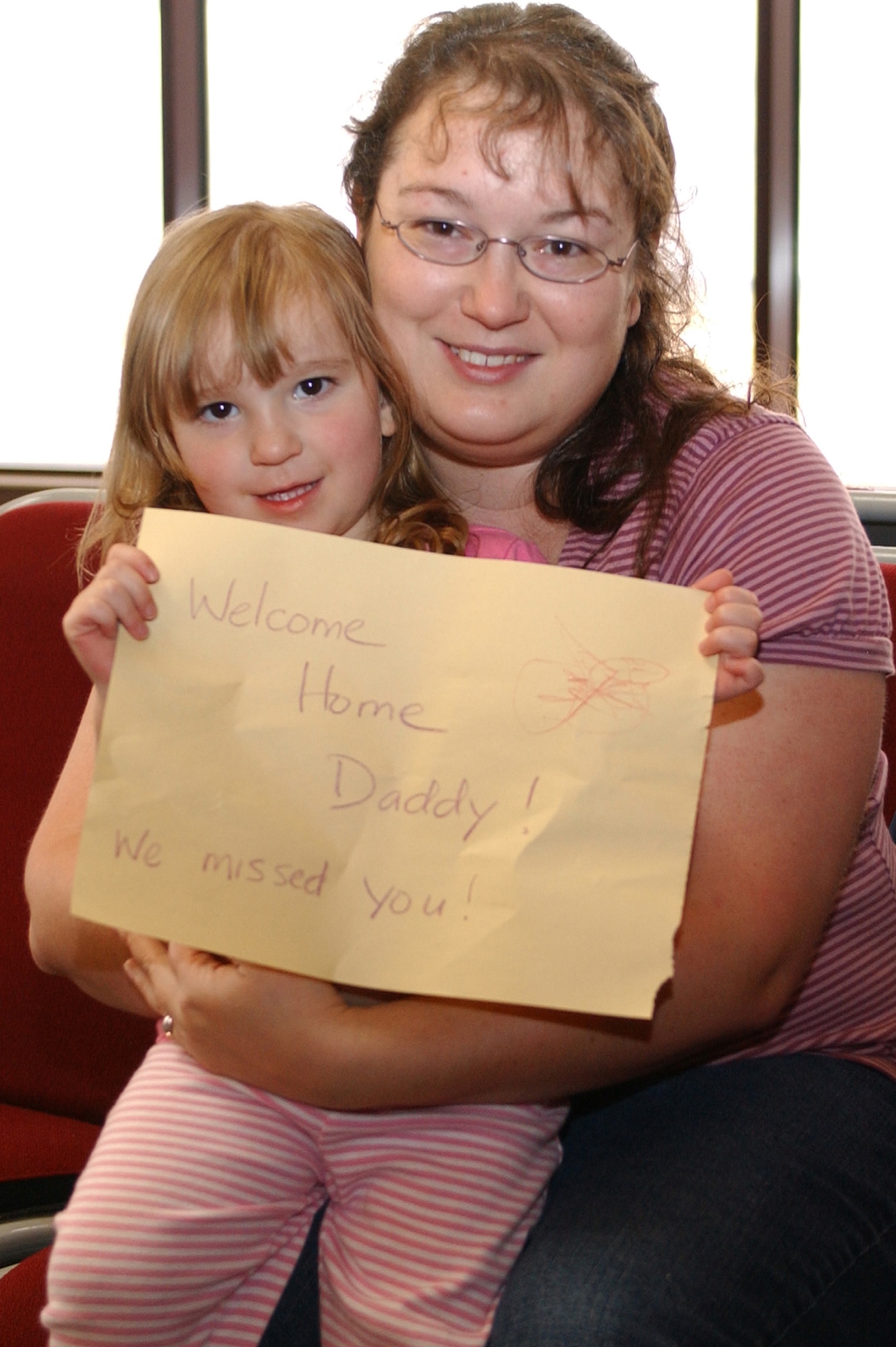 Carrie Justice, with her 2-year-old daughter Callie, waits patiently May 7 at the Colorado Springs airport for husband and father Tech. Sgt. Scott Justice to appear from the airport terminal. Sergeant Justice re-deployed with members of both the 21st Services and Space Communications Squadrons after four-and six-month deployments to Southwest Asia. “It’s been a long four months,” Mrs. Justice said. Sergeant Justice is assigned to the 21st SVS. (U.S. Air Force photo/Margie Arnold)
