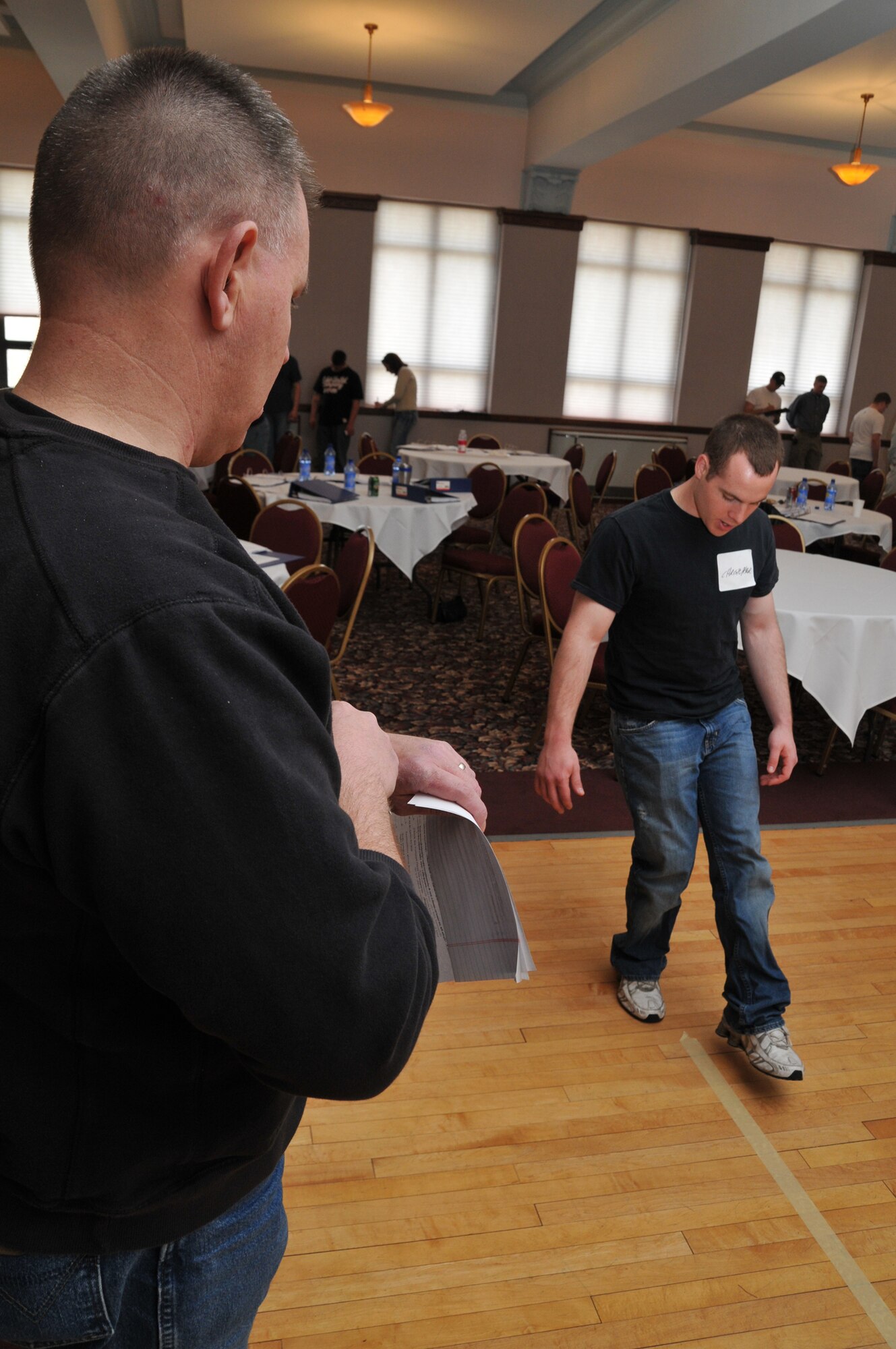 Airman Christopher Peters, 741st Missile Security Forces Squadron, prepares to walk the straight line for Cascade County reserve deputy sheriff Kevin Lake, during Field Sobriety Training at the Civic Center April 29. Airman Peters volunteered to be one of the subjects evaluated after drinking a prescribed amount of alcohol. The training was funded by federal grant money managed by the Enforcing Underage Drinking Laws committee. (U.S. Air Force photo/John Turner)