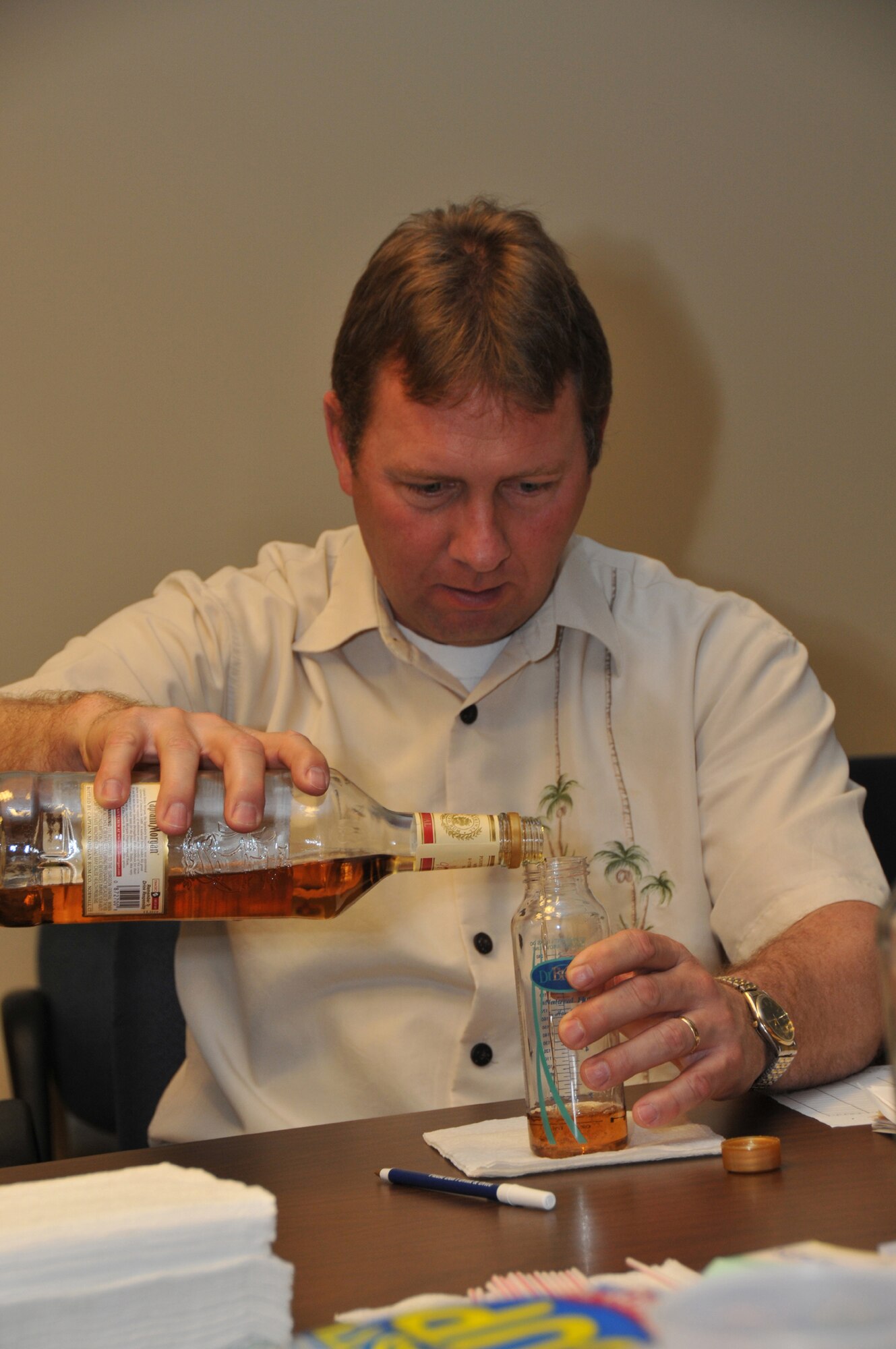 Officer Kelly Mantooth from the Montana Highway Patrol pours a predetermined amount of alcohol into a countainer for one of the volunteers to drink during a Field Sobriety Training class April 29. After the volunteers consumed the predetermined amount of alcohol for each of them based on their age, height and weight, they were put through a series of tests by the students, all members of law enforcement. (U.S. Air Force photo/John Turner)