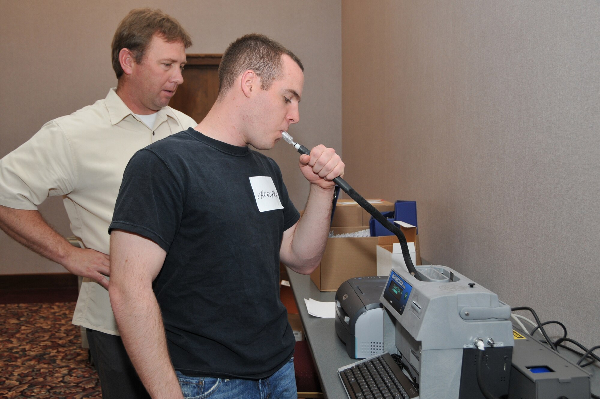 Officer Kelly Mantooth from the Montana Highway Patrol watches for the results to appear as Airman Christopher Peters, 741st Missile Security Forces Squadron, submitts to a breathalyzer test after consuming a predetermined amount of alcohol. He was a volunteer during Field Sobriety Training April 29 at the Civic Center. (U.S. Air Force photo/John Turner)