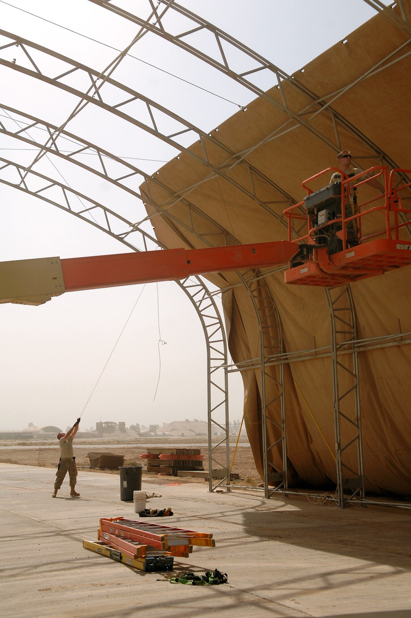 Airmen from the 332nd Expeditionary Civil Engineer Squadron structural engineer shop raise a big top shelter canopy May 7 at Balad Air Base, Iraq. The shelter was moved from its previous location to deconflict with flightline operations. (U.S. Air Force photo/Senior Airman Julianne Showalter) 
