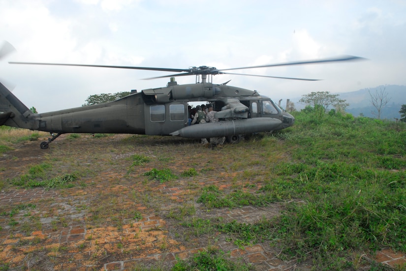 COMALAPA AIR BASE, El Salvador - From the landing zone on top of a 3,000 foot mountain near San Salvador, a UH-60 Blackhawk helicopter crew straps  two ?injured? civilians and two medical emergency personnel for a five-minute flight to San Salvador during Fuerzas Aliadas Humanitarias 2008.  (U.S. Air Force photo by Tech. Sgt. William Farrow)