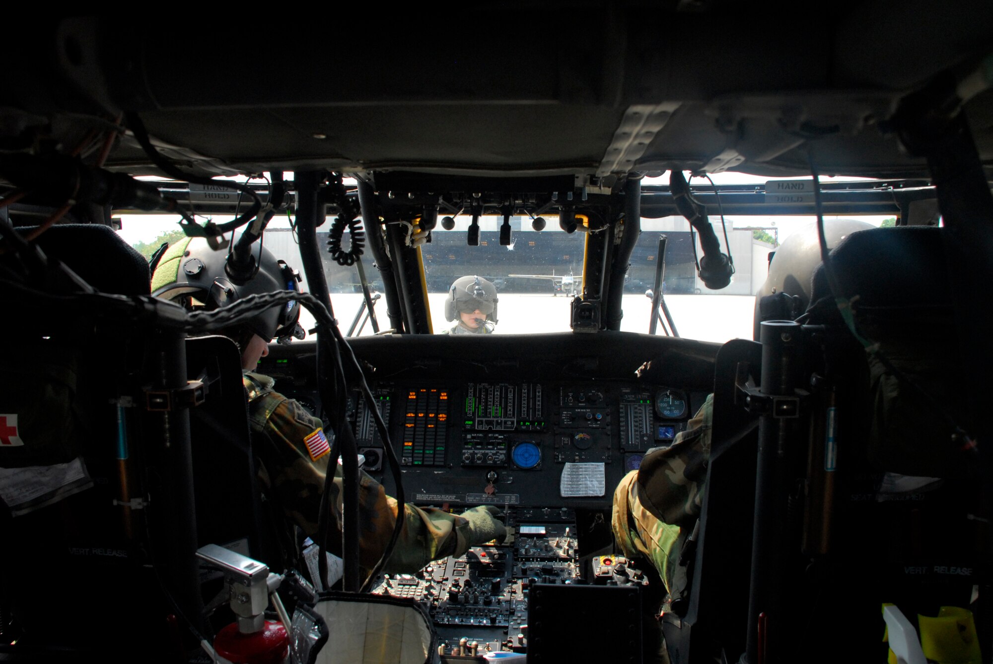 COMALAPA AIR BASE, El Salvador - Spec. Harlan Nemmers, crew chief, waits as pilot Chief Warrant Officer Emile Eckart (right) and co-pilot Chief Warrant Officer Shamus Kirschbaum run through systems checks prior to taking off May 6 for Fuerzas Aliadas Humanitarias 2008, a disaster relief exercise.  (U.S. Air Force photo by Tech. Sgt. William Farrow)