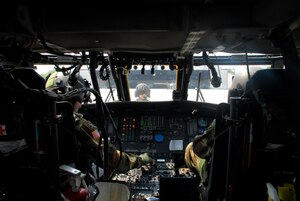 COMALAPA AIR BASE, El Salvador - Spec. Harlan Nemmers, crew chief, waits as pilot Chief Warrant Officer Emile Eckart (right) and co-pilot Chief Warrant Officer Shamus Kirschbaum run through systems checks prior to taking off May 6 for Fuerzas Aliadas Humanitarias 2008, a disaster relief exercise.  (U.S. Air Force photo by Tech. Sgt. William Farrow)