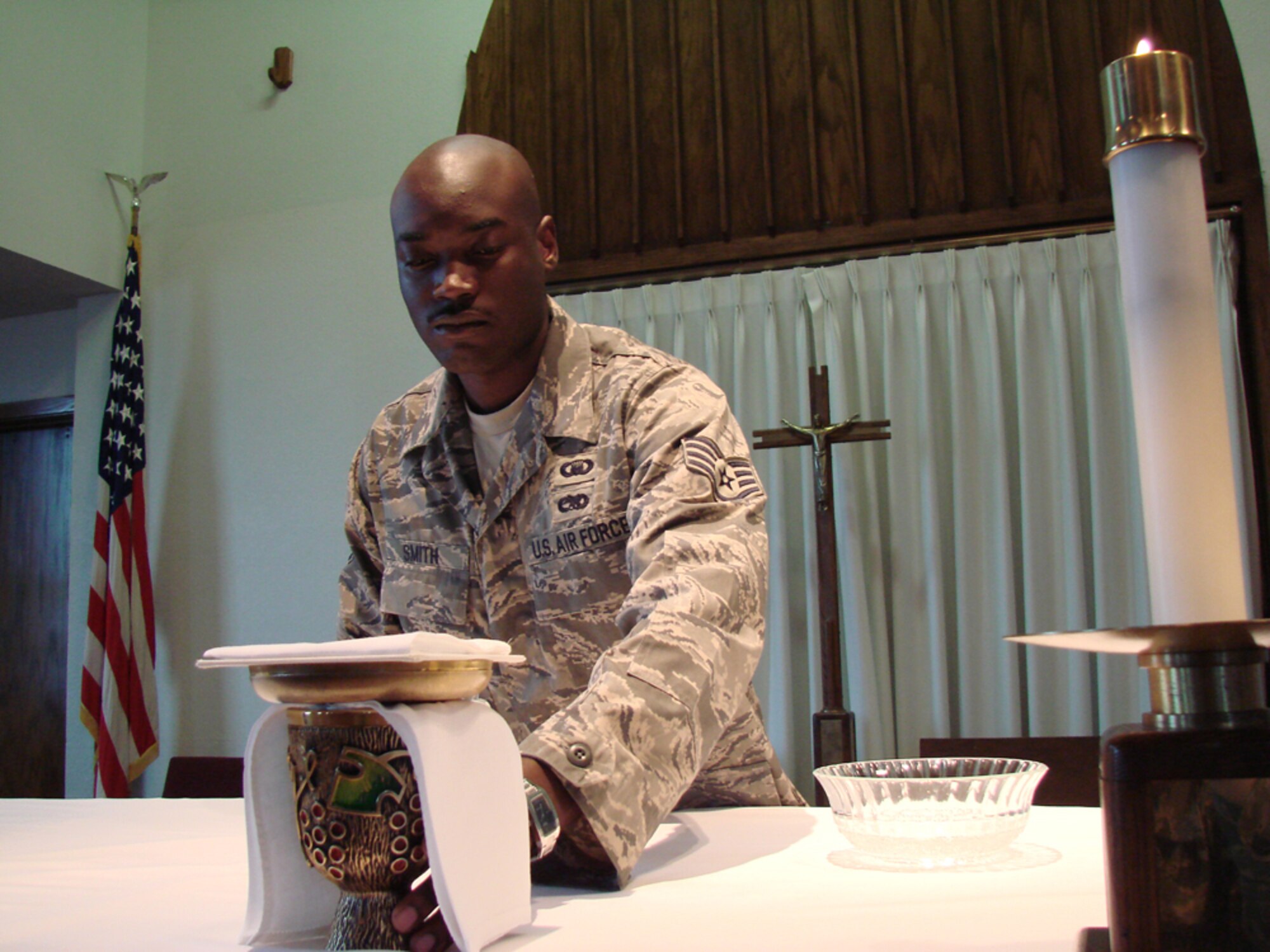 Staff Sgt. Terrell Smith, NCO in Charge of Chapel Operations, prepares the altar for a Vance church service. Sergeant Smith is the May Warrior of the Month for his dedicated service to Vance quality of life programs and mission-related  programs. (U.S. Air Force photo by Tech. Sgt. Mary Davis)