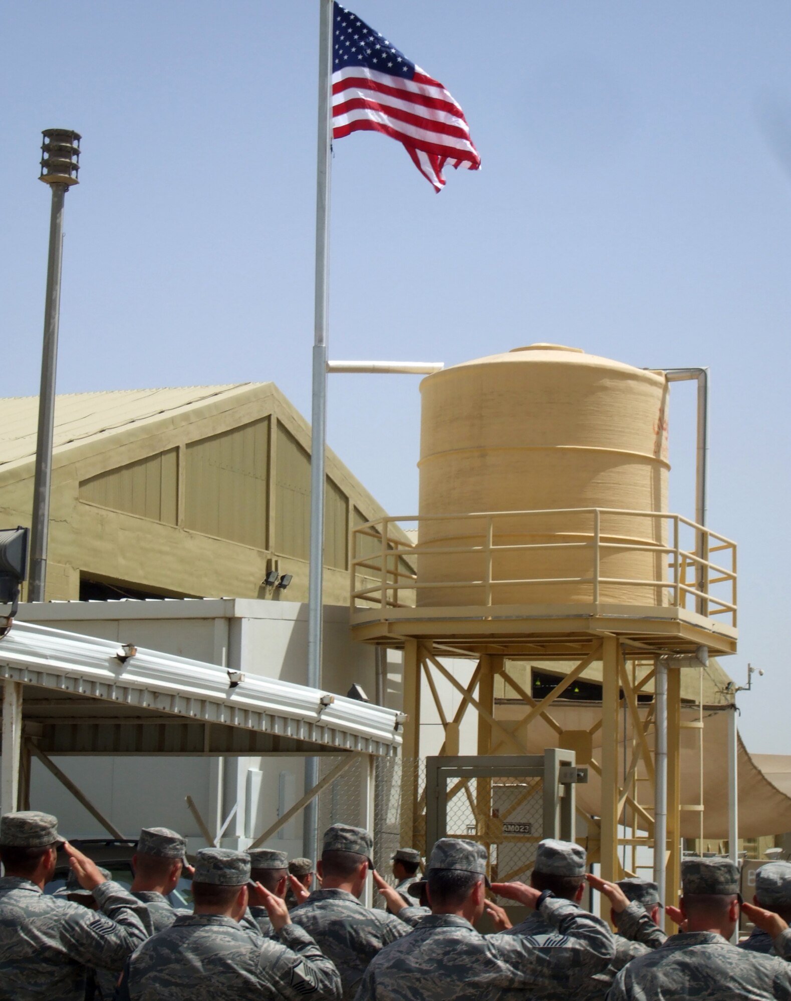 SOUTHWEST ASIA -- Airmen from the 387th Air Expeditionary Group salute the U.S. flag during a joint flag raising ceremony with the host nation's Air Force on April 22, 2008, at an air base in the Persian Gulf Region.  The ceremony commemorated the partnership between the two countries and the one-year-mark since the group stood up operations.  (U.S. Air Force photo/Capt. Ephane Dubose)