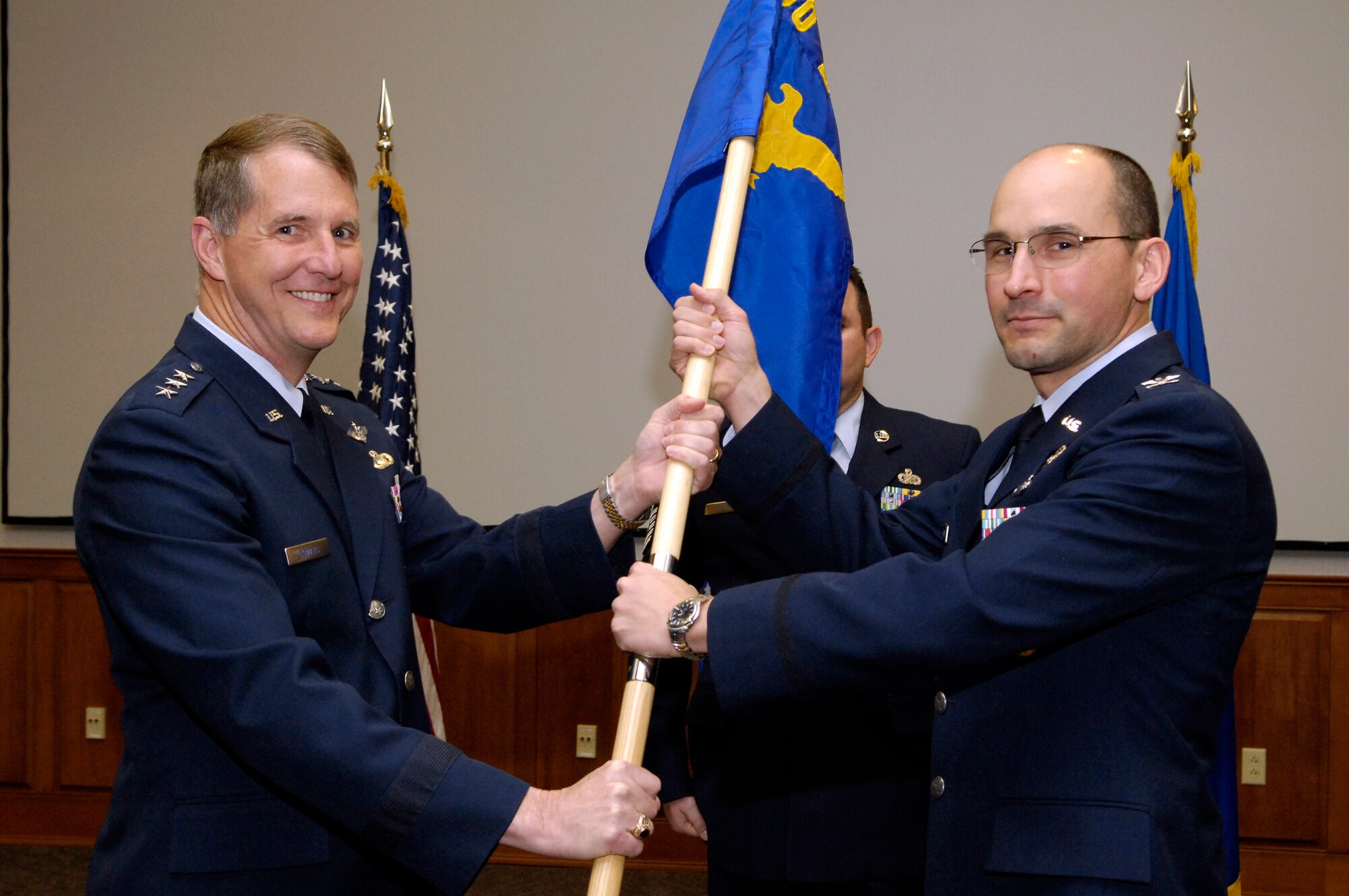 HANSCOM AFB, Mass. - Electronic Systems Center Commander Lt. Gen. Ted Bowlds (left) passes the 350th Electronic Systems Wing guidon to Col. Robert Dominguez during an appointment to command ceremony May 2. Prior to this post, Colonel Dominguez served as deputy director of Coalition Warfare at the Office of the Secretary of Defense in Washington, D.C.  (Photo by Mark Wyatt)
