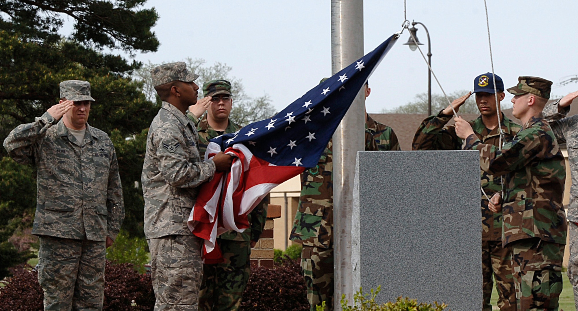 MCCONNELL AIR FORCE BASE, Kan. -- Airman 1st Class Nicholas Johnson and Senior Airman Keith Wines, 22nd Maintenance Squadron, bring down the flag in front of the headquarters building during retreat, May 1. Retreat serves two purposes, signals the end of the official duty day and as a ceremony to pay respect to the American flag. (Photo by Airman 1st Class Maria Ruiz)