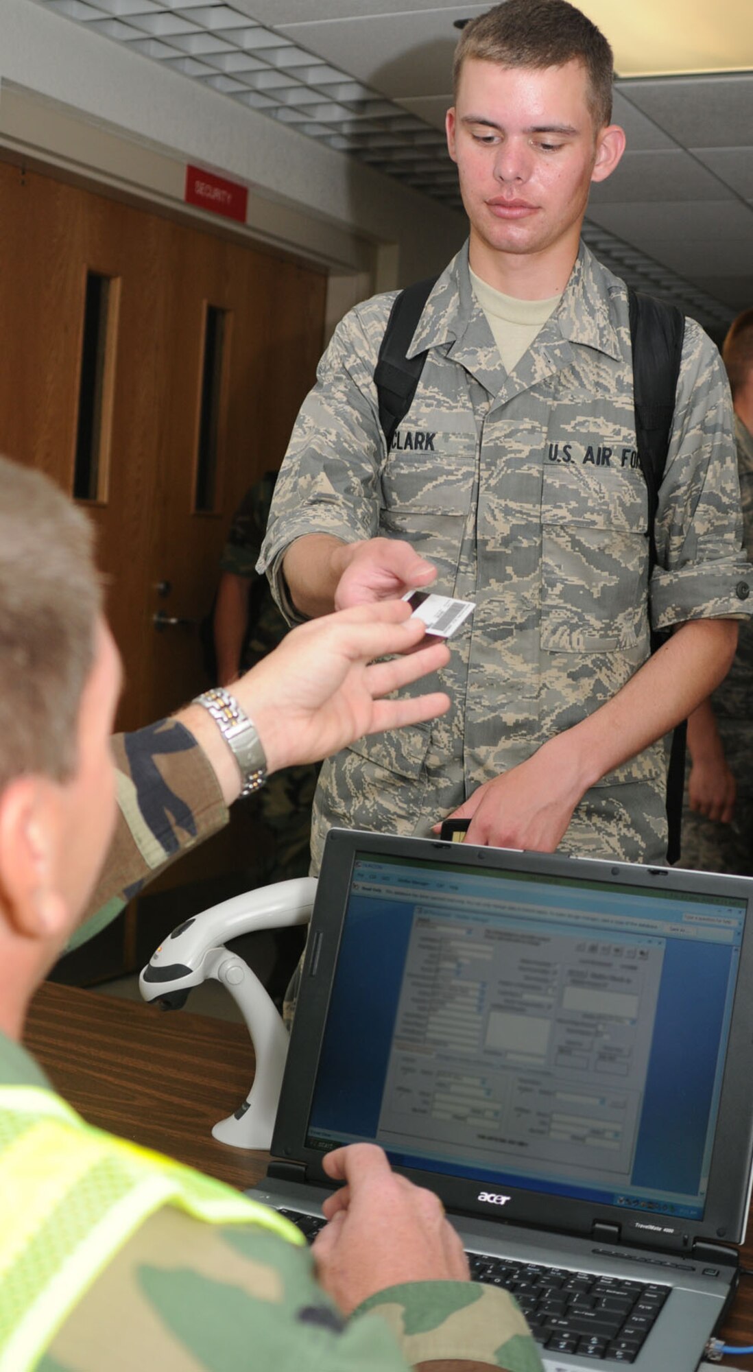 Master Sgt. Tony Yaughn, 335th Training Squadron, checks in one of his unit’s students, Airman Basic Gregory Clark, to the shelter at Wolfe Hall Friday during the hurricane exercise.  (U.S. Air Force photo by Kemberly Groue)