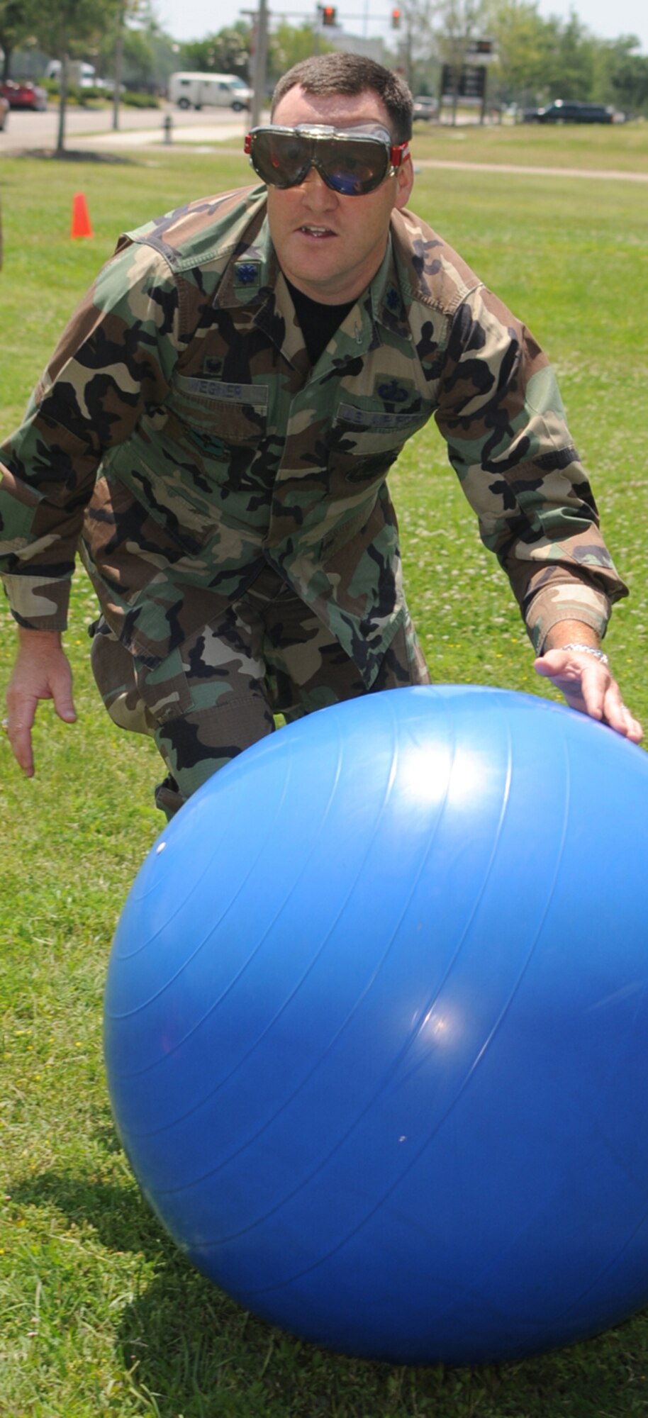 Chris Wegner, 81st Contracting Squadron, rolls a ball around cones while wearing “drunk goggles” during the dizzy obstacle course for commanders on the Blake Fitness Center grounds.  (U.S. Air Force photo by Kemberly Groue)