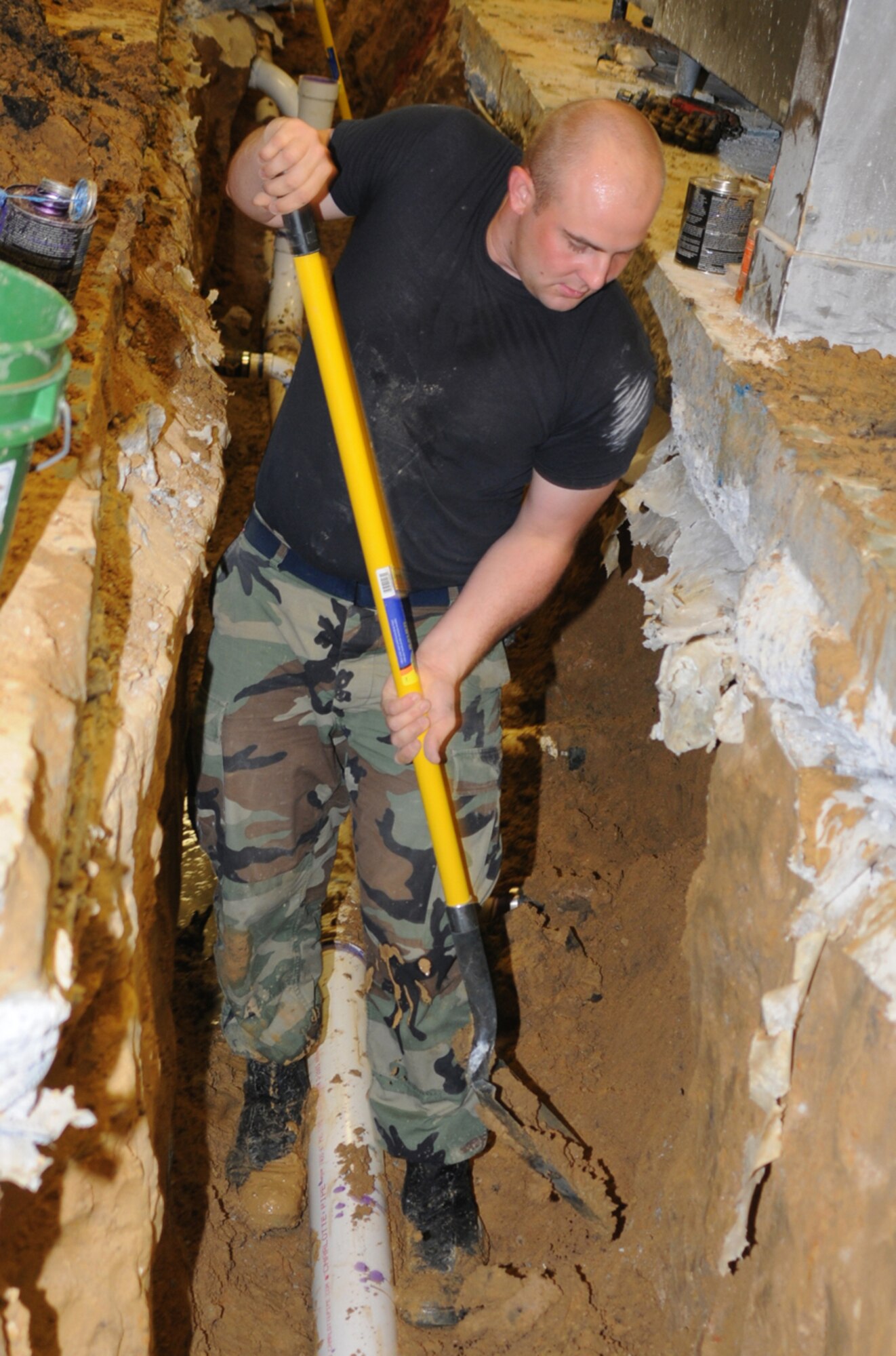 Senior Airman Lloyd Sheteron, 81st CES, shovels dirt away from the new pipe being installed.  Options to repair the facility’s floors are now being evaluated.  (U.S. Air Force photo by Kemberly Groue)