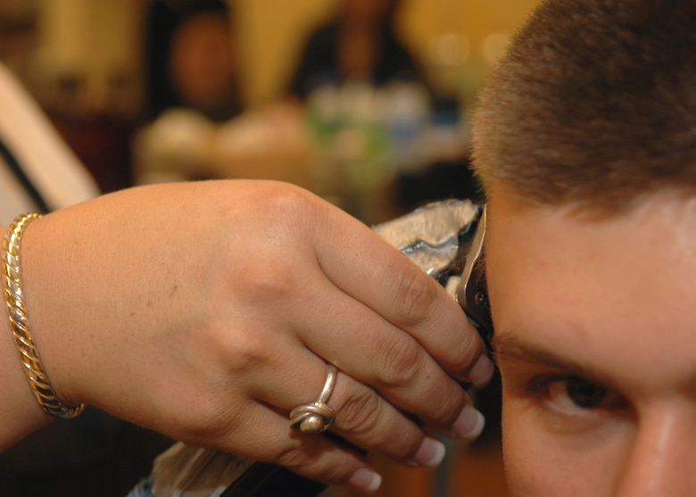 DYESS AIR FORCE BASE, Texas -- AAFES employee Shayla Billeter uses a balding clipper to give Airman 1st Class Micheal Breaux his new haircut at the Base Exchange barber shop May 7. Balding clippers are one of the most commonly used tools at the barber shop. (U.S. Air Force Photo by Airman 1st Class Stephen Reyes) 