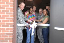 MINOT AIR FORCE BASE, N.D. -- Col. Joel Westa, 5th Bomb Wing commander, assists Airmen in a ribbon cutting ceremony held to re-open the Airman Center here May 3. Also present at the ribbon-cutting were Col. Gregory Tims, 91st Space Wing vice commander; Chief Master Sgt. Mark Clark, 5th BW command chief; Chief Master Sgt. Mark Brejcha, 91st SW command chief; and Airman 1st Class Asia Bailey and Senior Airman LaToya Fields, president and vice president of the Airman's Council. The re-opening coincided with the Cinco De Mayo festival that was held at the Airman's Center. (U.S. Air Force photo by Senior Airman Cassandra Jones)
