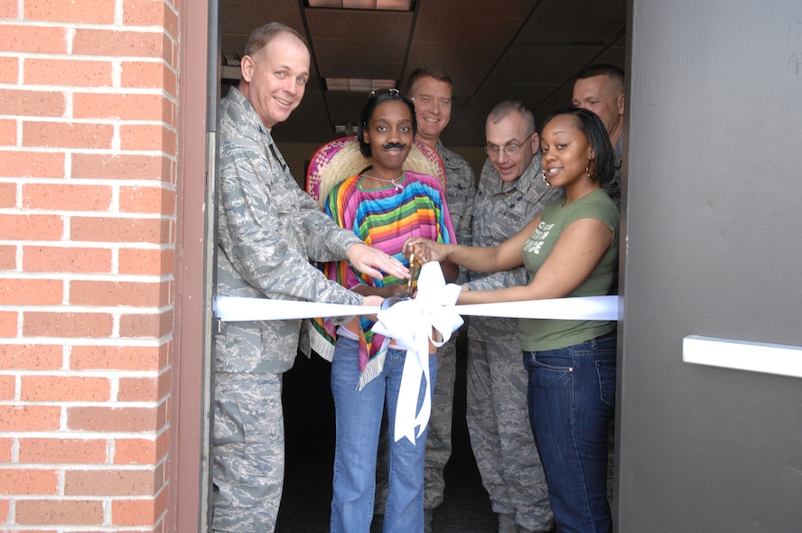 MINOT AIR FORCE BASE, N.D. -- Col. Joel Westa, 5th Bomb Wing commander, assists Airmen in a ribbon cutting ceremony held to re-open the Airman Center here May 3. Also present at the ribbon-cutting were Col. Gregory Tims, 91st Space Wing vice commander; Chief Master Sgt. Mark Clark, 5th BW command chief; Chief Master Sgt. Mark Brejcha, 91st SW command chief; and Airman 1st Class Asia Bailey and Senior Airman LaToya Fields, president and vice president of the Airman's Council. The re-opening coincided with the Cinco De Mayo festival that was held at the Airman's Center. (U.S. Air Force photo by Senior Airman Cassandra Jones)
