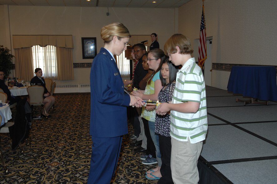 MINOT AIR FORCE BASE, N.D.-Children from Memorial Middle School here perform
a candle-lighting ceremony during a Jewish prayer at the Holocaust Days of
Remembrance luncheon April 29. Along with prayers, excerpts from various
books and poems written by Holocaust survivors were read. (U.S. Air Force
photo by Senior Airman Cassandra Jones)

