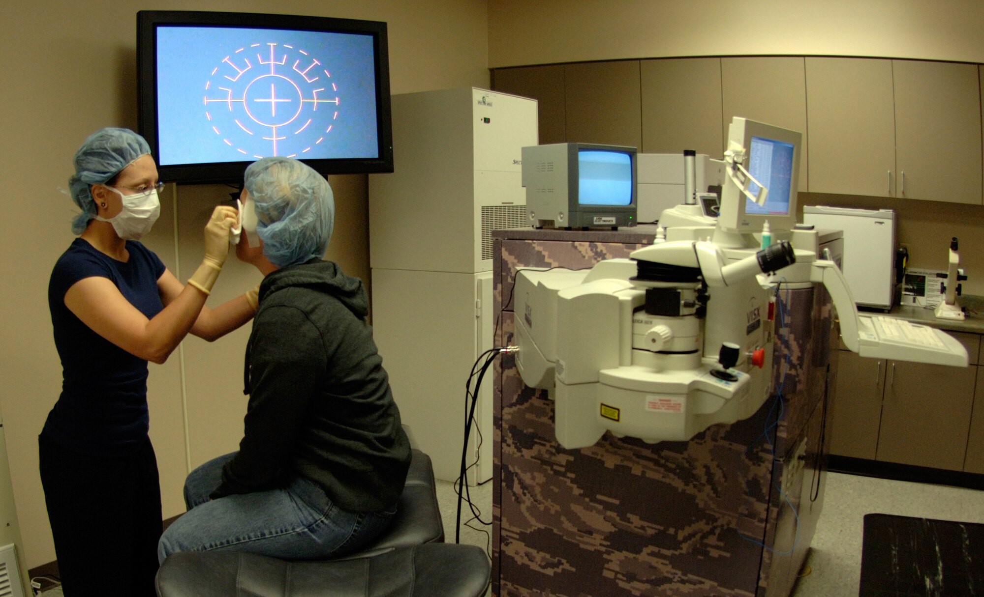 Misty Copeland, ophthalmic technician in the 59th Surgical Specialties Squadron (left), prepares a patient's eyes for laser surgery March 26 at the Joint Warfighter Refractive Surgery Center, Lackland Air Force Base, Texas. Numbing drops are put in the patient's eye to prevent pain during the procedure. (U.S. Air Force photo/Master Sgt. Kimberly A. Yearyean-Siers)