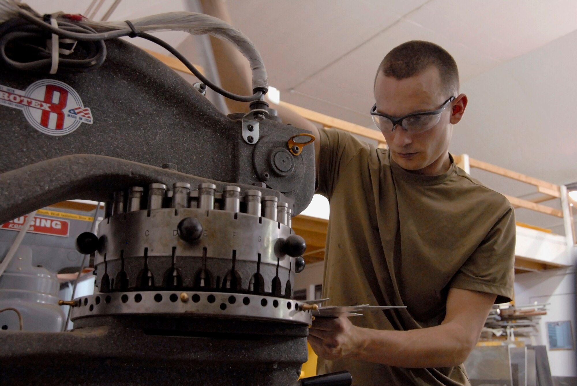 SOUTHWEST ASIA -- Airman 1st Class Richard Clemons, an aircraft structural maintainer deployed to the 386th Expeditionary Maintenance Squadron metals flight, uses a rotary punch to fabricate a piece of sheet metal that will be used as a patch for a repair on a C-130 Hercules May 6, 2008, at an air base in the Persian Gulf Region. The primary mission of the Metals flight is to provide direct support to all of the structural components of an aircraft and its supporting equipment in support of the Global War on Terror. Airman Clemons is deployed from the 7th Equipment Maintenance Squadron, Dyess Air Force Base, Texas. (U.S. Air Force photo/ Staff Sgt. Patrick Dixon)