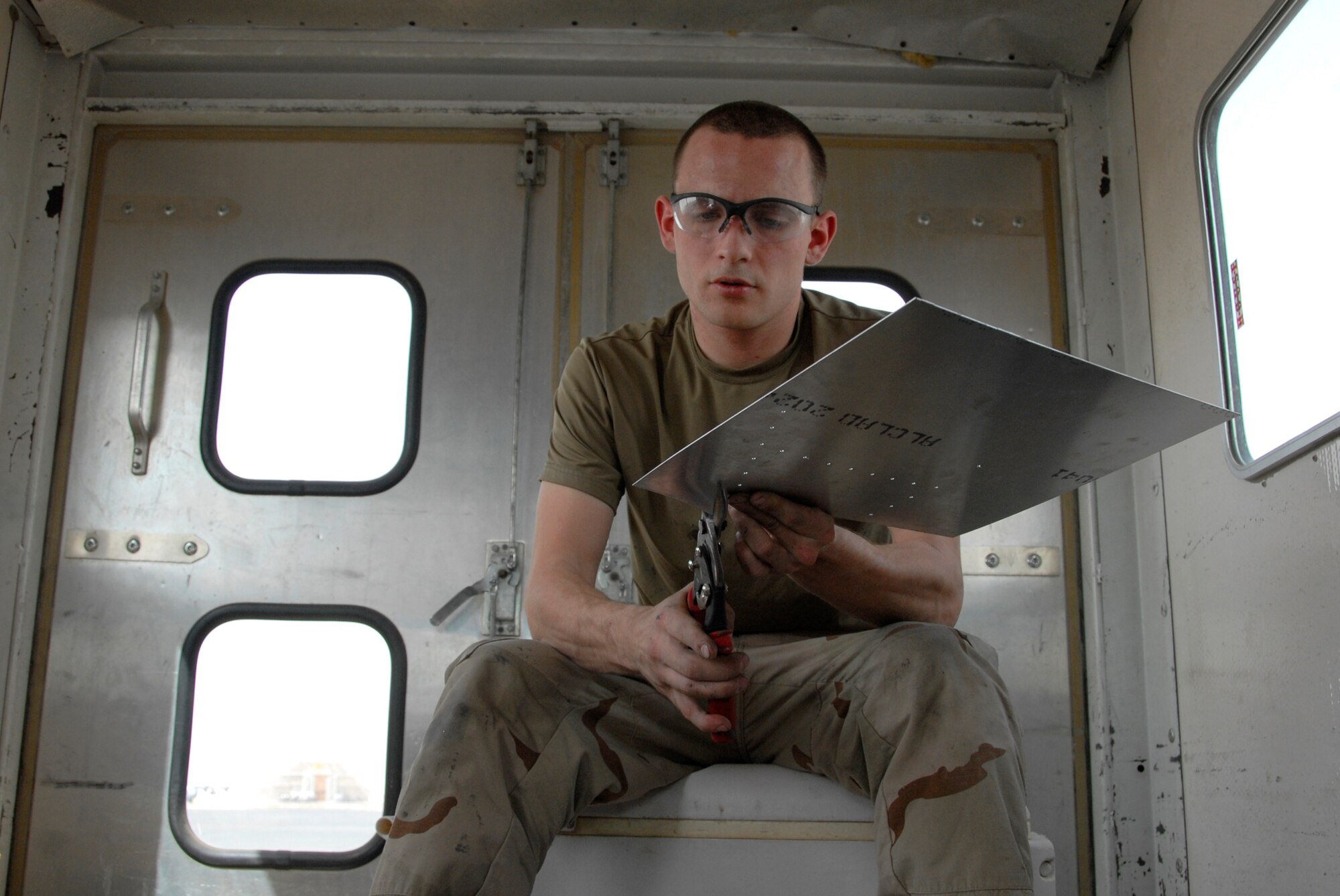 SOUTHWEST ASIA -- Airman 1st Class Richard Clemons, an aircraft structural maintainer deployed to the 386th Expeditionary Maintenance Squadron metals flight, cuts a piece of sheet metal that will be used as a patch for a repair on a C-130 Hercules May 6, 2008, at an air base in the Persian Gulf Region. The primary mission of the metals flight is to provide direct support to all of the structural components of an aircraft and its supporting equipment in support of the Global War on Terror. Airman Clemons is deployed from the 7th Equipment Maintenance Squadron, Dyess Air Force Base, Texas. (U.S. Air Force photo/ Staff Sgt. Patrick Dixon)