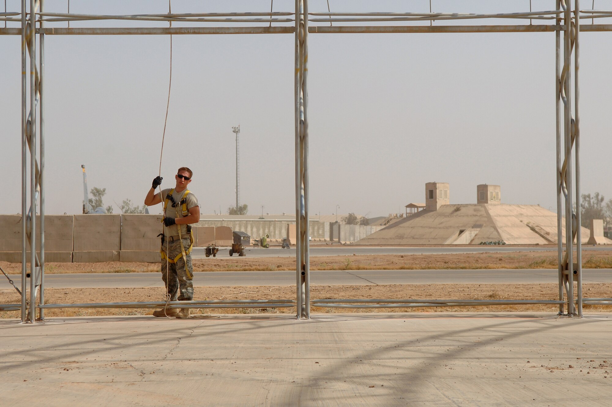 BALAD AIR BASE, Iraq -- Senior Airman James Robison, 332nd Expeditionary Civil Engineer Squadron structural engineer, holds a lead rope before the canopy is raised over the skeleton of a big top shelter here, May 7. These shelters are used to house and protect aircraft and equipment from the elements. Airman Robison is deployed from Malmstrom Air Force Base, Mont. (U.S. Air Force photo/ Senior Airman Julianne Showalter)