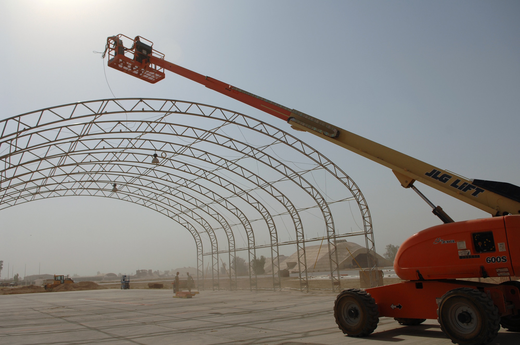 BALAD AIR BASE, Iraq -- Staff Sgt. Karl Ferree and Senior Airman James Robison, 332nd Expeditionary Civil Engineer Squadron structural engineers, position lead ropes on a big top shelter with a bucket truck here, May 7. The shelter can house various aircraft and equipment. Sergeant Ferree is deployed from Luke Air Force Base, Ariz., and Airman Robison is deployed from Malmstrom Air Force Base, Mont. (U.S. Air Force photo/ Senior Airman Julianne Showalter)