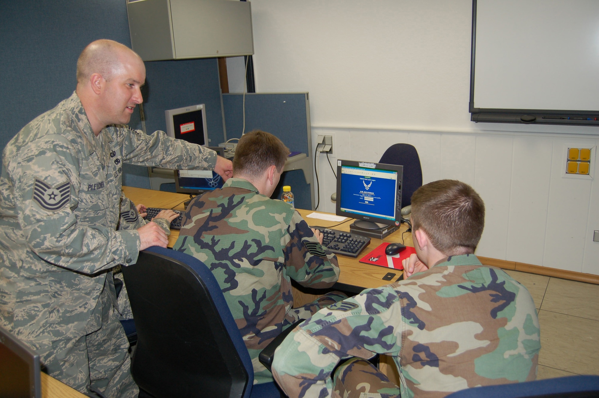 Tech. Sgt. Robert Pletcher (standing) and Tech. Sgt. Derron Cockayne, both assigned to the 1st Air and Space Communications Operations Squdron, demonstrate TBMCS-UL classroom preparation procedures to newly assigned Senior Airman Thomas Callan.(Courtesy Photo)  