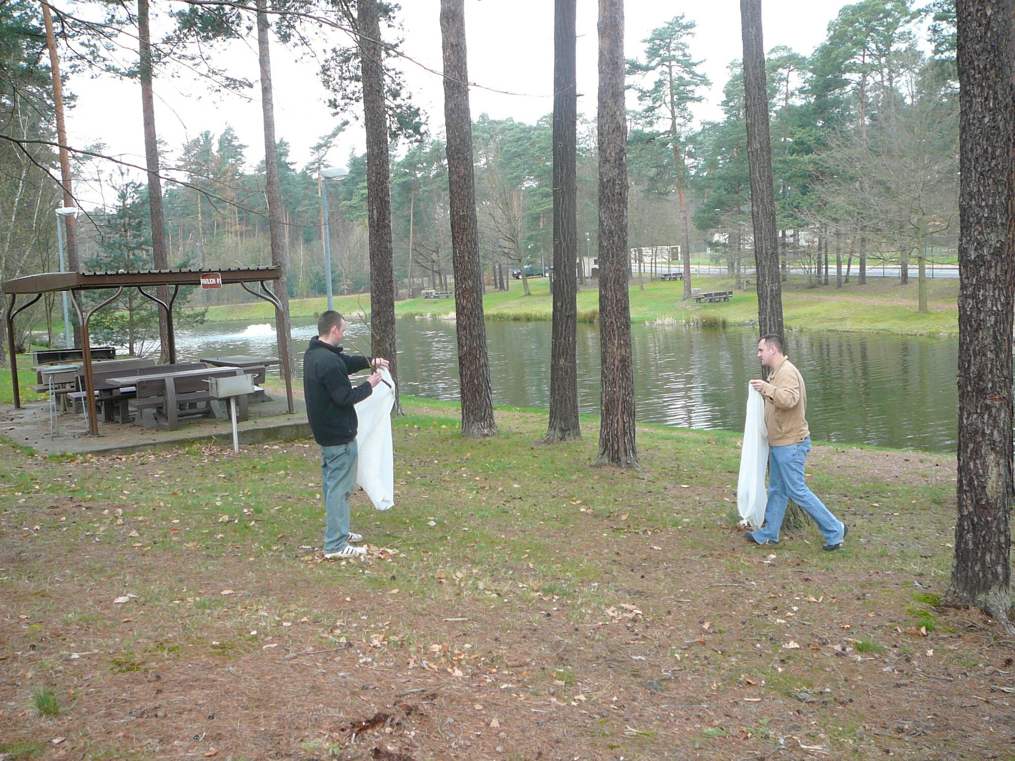 (from left) Senior Airman Bryan Turner and Staff Sgt. Talmadge Beasley, 1st Combat Communications Squadron members,  work together to clean up the area around Ramstein Lake. 1st CBCS Bravo Flight participates in the Adopt An Area Program. (Courtesy Photo)