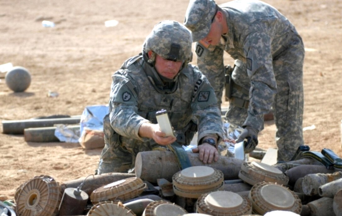 U.S. Army Sgt. Christopher Gray and U.S. Air Force Staff Sgt. Anthony Sayre place C4, a type of plastic explosive, to prepare to destroy the recovered munitions in Karbola, Iraq, May 3, 2008. 