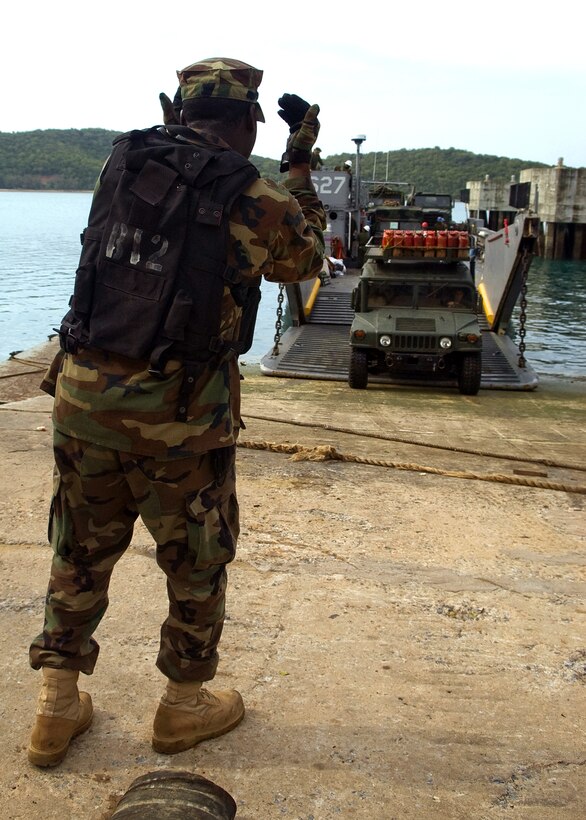 U.S. Navy Seaman Chris Smith directs a Humvee as it departs a landing craft, May 8, 2008. The landing craft transported elements of the 31st Marine Expeditionary Unit to shore from the forward-deployed amphibious assault ship USS Essex.