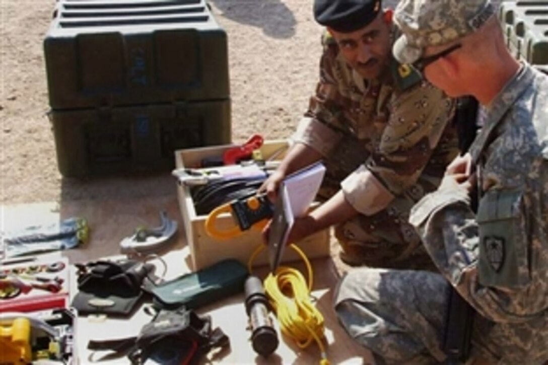 U.S. Army Spc. Matthew Grundyson explains the uses of multiple electrical construction tools to Maj. Haleem, the executive officer for the 6th Iraqi Army Engineer Battalion, May 7, 2008, Baghdad. Grundyson, an electrician, is assigned to the 769th Engineer Battalion, 35th Engineer Brigade. 