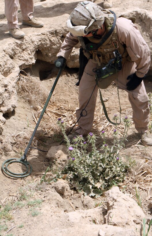RAMADI, Iraq – Cpl. Earen B. Dunham, a combat engineer with 2nd Combat Engineer Battalion, attached to 1st Battalion, 9th Marine Regiment, Regimental Combat Team 1, scans the area with a metal detector in search of a possible weapons cache May 8. (Official U.S. Marine Corps photo by Lance Cpl. Casey Jones) (RELEASED)