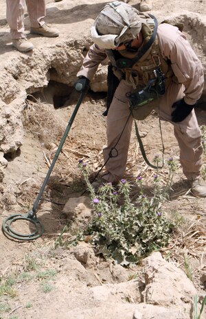 RAMADI, Iraq – Cpl. Earen B. Dunham, a combat engineer with 2nd Combat Engineer Battalion, attached to 1st Battalion, 9th Marine Regiment, Regimental Combat Team 1, scans the area with a metal detector in search of a possible weapons cache May 8. (Official U.S. Marine Corps photo by Lance Cpl. Casey Jones) (RELEASED)