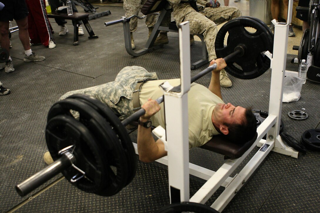 Army Staff Sgt. Joseph Bouchard with the 169th Military Police Company, Police Transition Team, 2nd Battalion, 2nd Marine Regiment, Regimental Combat Team 5, competes in the bench-press event of the superman competition held at the Morale Welfare and Recreation Center in Al Qa'im, Iraq, May 8. MWR holds this event once a month for service members to test their strength against one another.