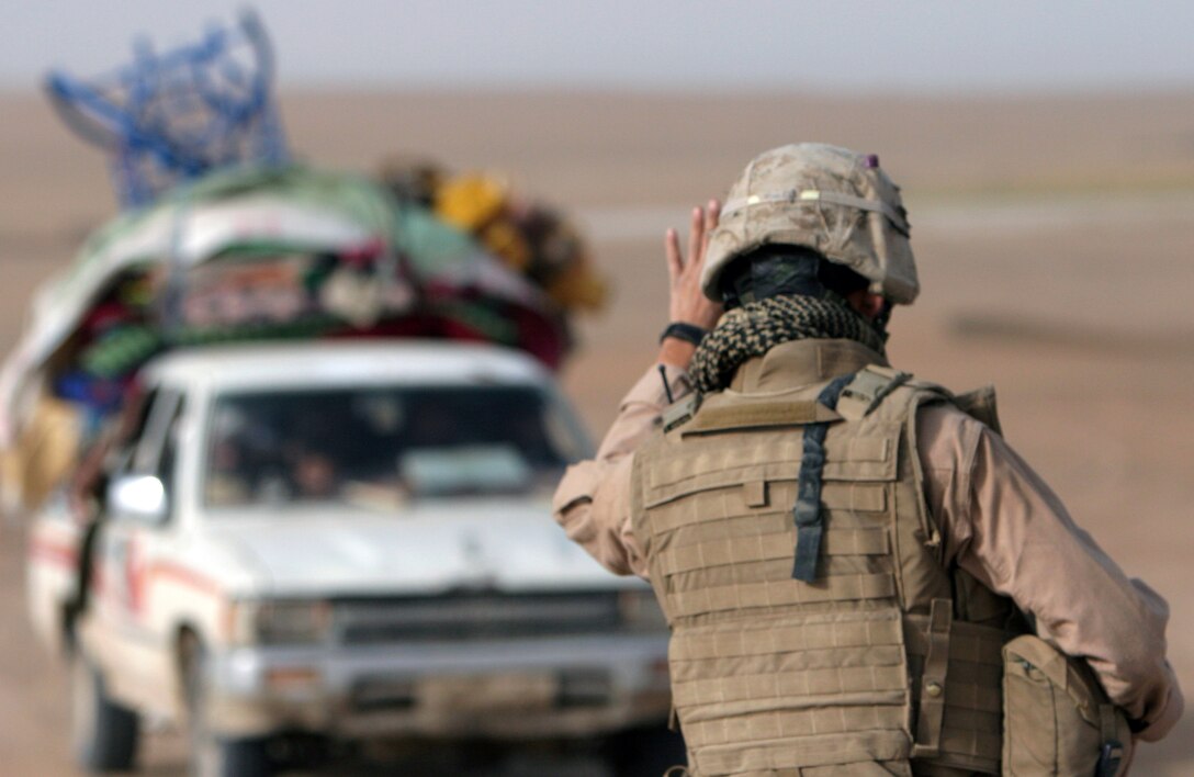 Cpl. Mathew Hutson, vehicle commander, 1st Combined Arms Platoon, Weapons Company, Battalion Landing Team 1st Battalion, 6th Marine Regiment, 24th Marine Expeditionary Unit, signals for a vehicle to stop at a checkpoint in Helmand Province, Afghanistan. The Marines of Weapons Company set up a vehicle control point to deny Taliban fighters a key supply route.