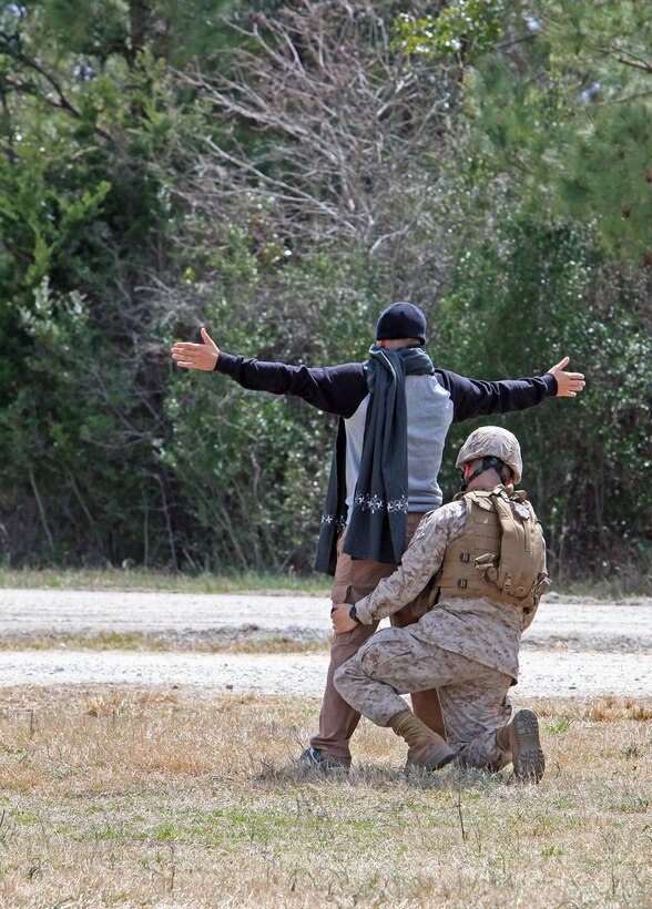 A Marine from 2nd Intelligence Battalion, II Marine Expeditionary Force Headquarters Group, pats down a role-player during a field exercise aboard Marine Corps Base Camp Lejeune, N.C., March 26, 2010. During the 11-day exercise, II MHG partnered with three of their major subordinate commands; the 2nd Intelligence, 2nd Radio and 8th Communications Battalions to set up and operate an expeditionary headquarters in the field.