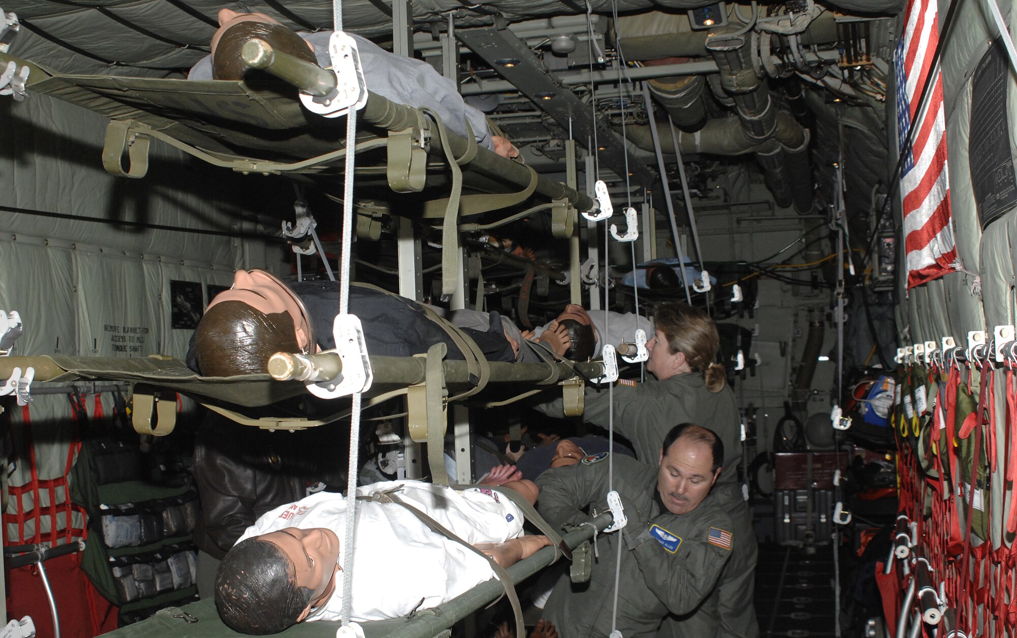 Master Sgt. Dave Allen, foreground, and Master Sgt. Marla Gilson, Reserve Airmen from the 446th Aeromedical Evaucation Squadron, McChord Air Force Base, Wash., configure 50 mannequins on a C-130 aircraft during a national-level mass casualty response exercise May 6. (U.S. Air Force photo/Adamarie Lewiis-Page)